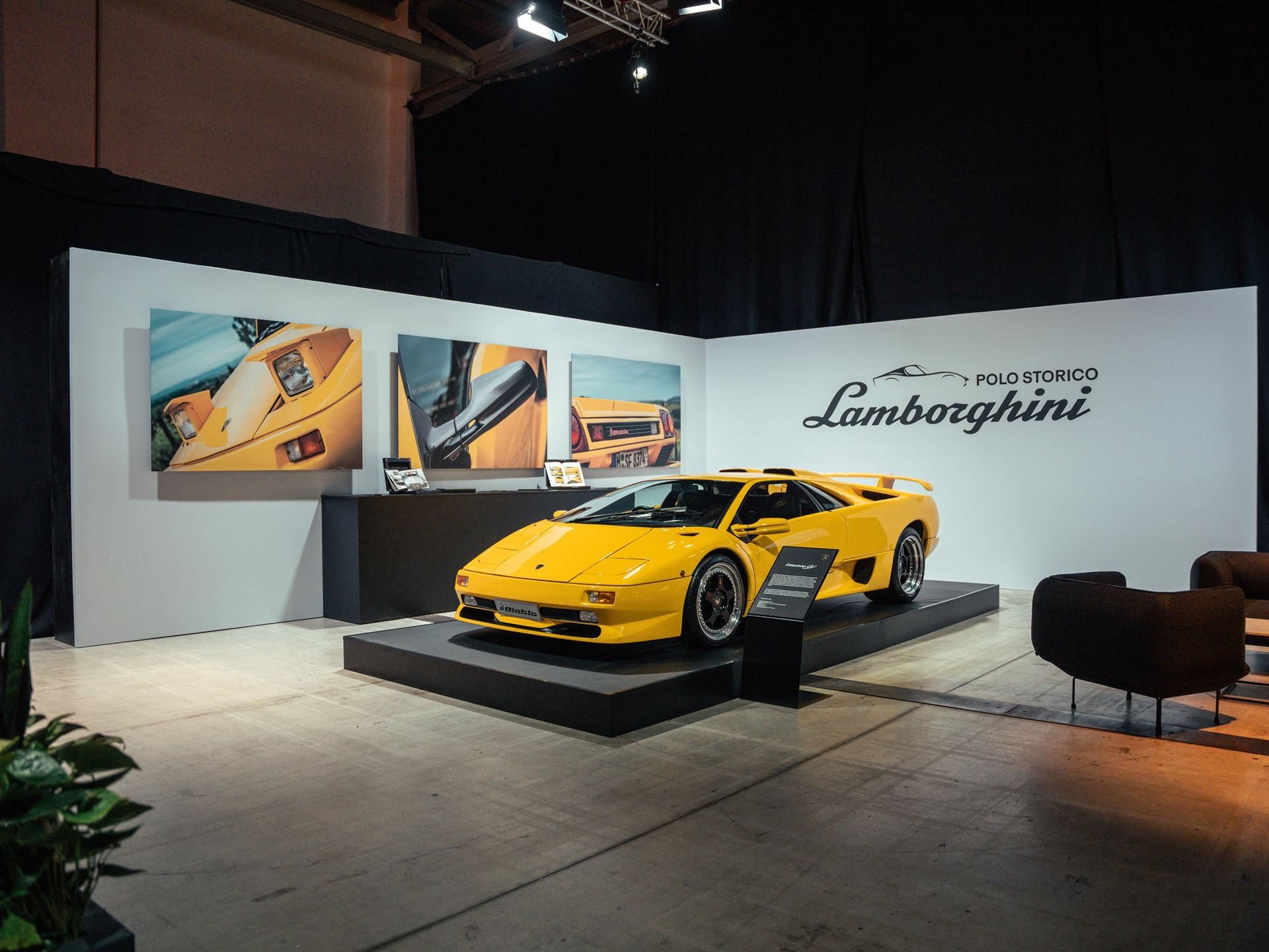 Bright yellow lamborghini diablo vt displayed on a black platform at a polo storico event