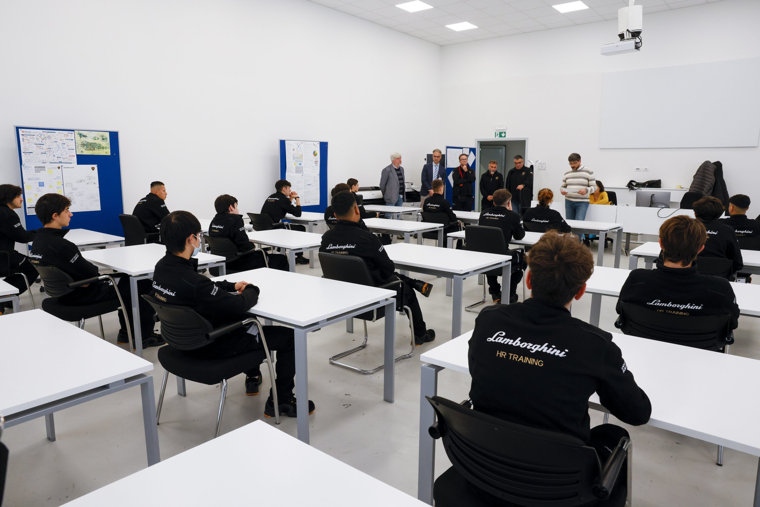 Inside Lamborghini'S Desi Program, Where 24 Students Train To Build Supercars 3 Wide shot of desi students in lamborghini hr training jackets seated at desks in a modern classroom at sant'agata bolognese