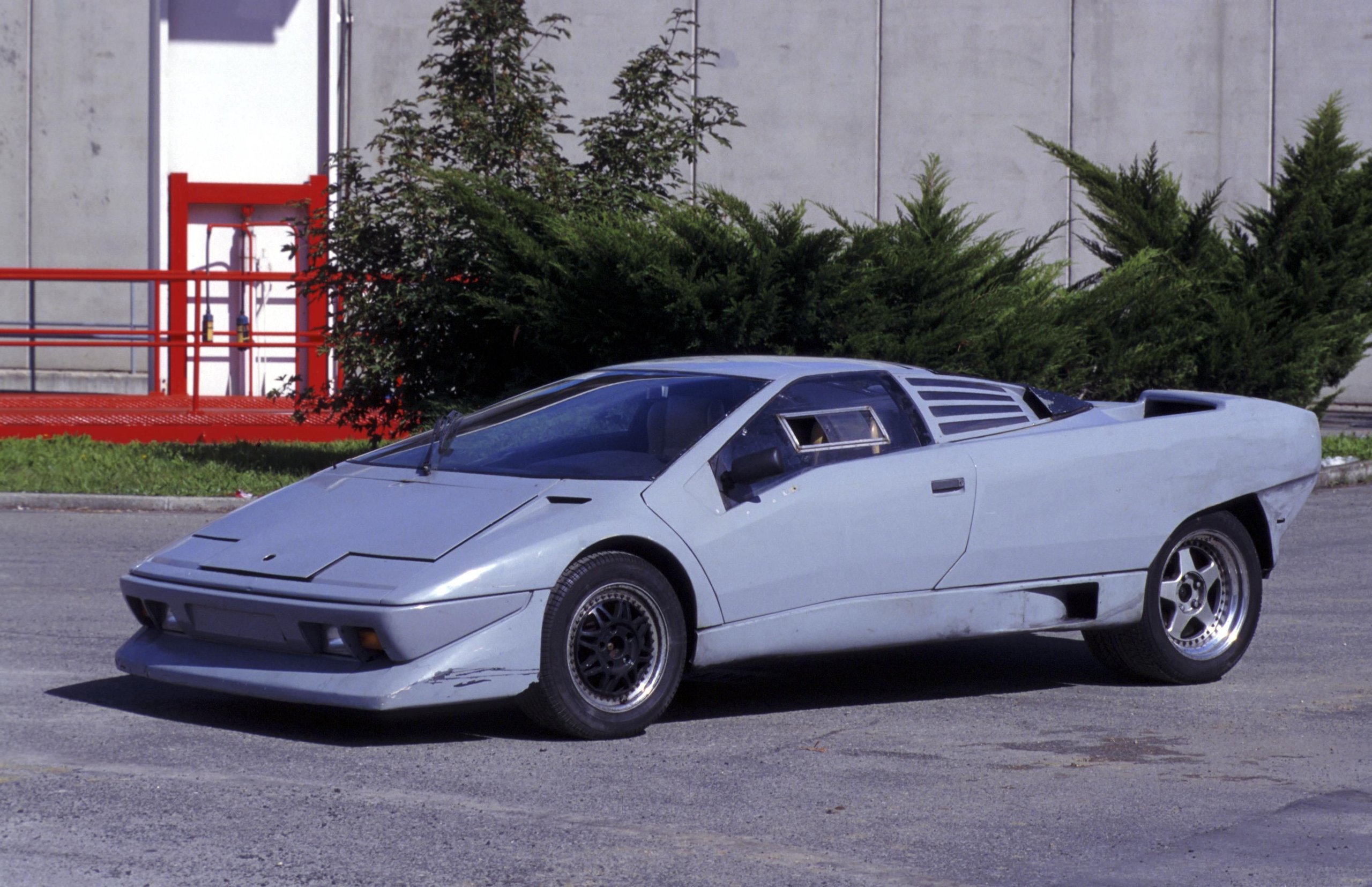 Front three-quarter view of a grey Lamborghini P132 prototype showing unpainted body and early design on an outdoor test track