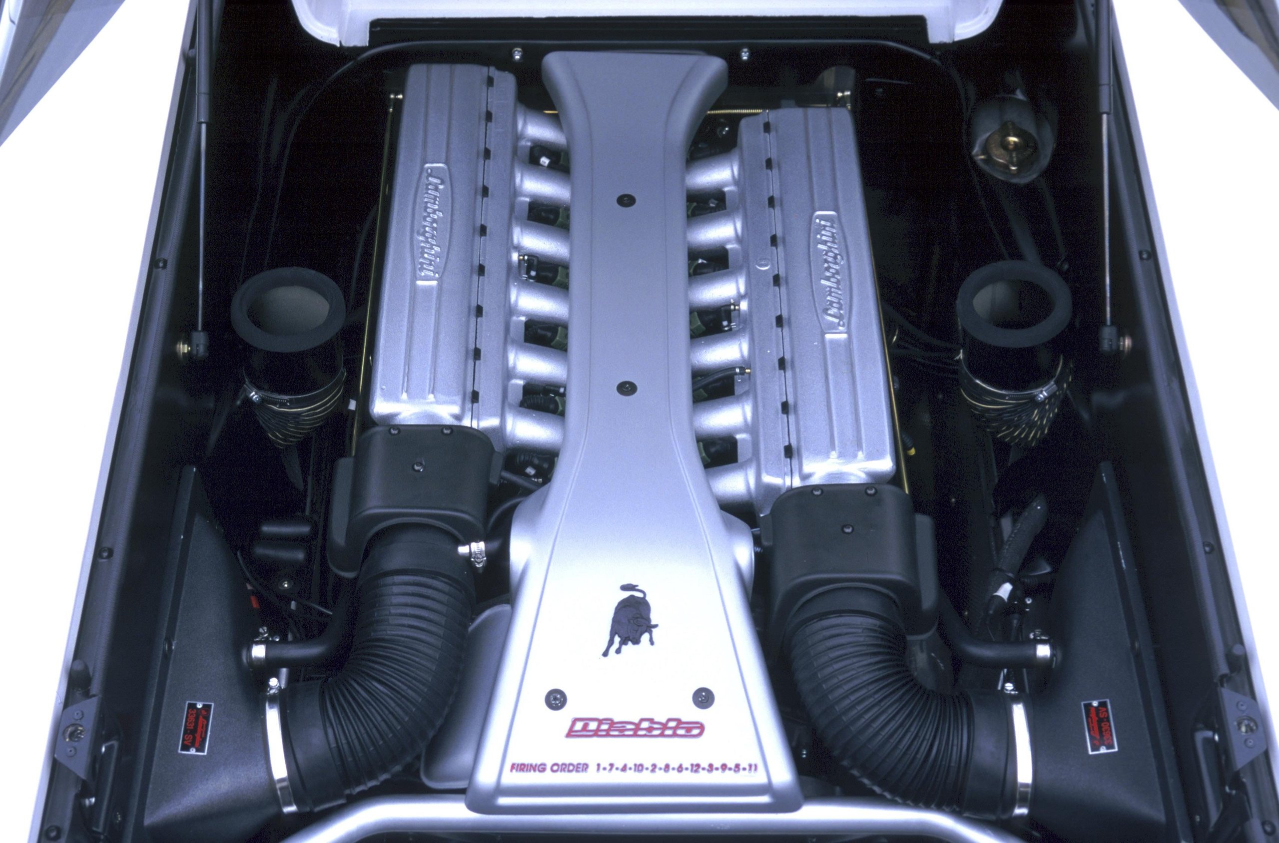 Top-down view of the Lamborghini Diablo V12 engine showing symmetrical intake manifolds and Lamborghini branding on valve covers