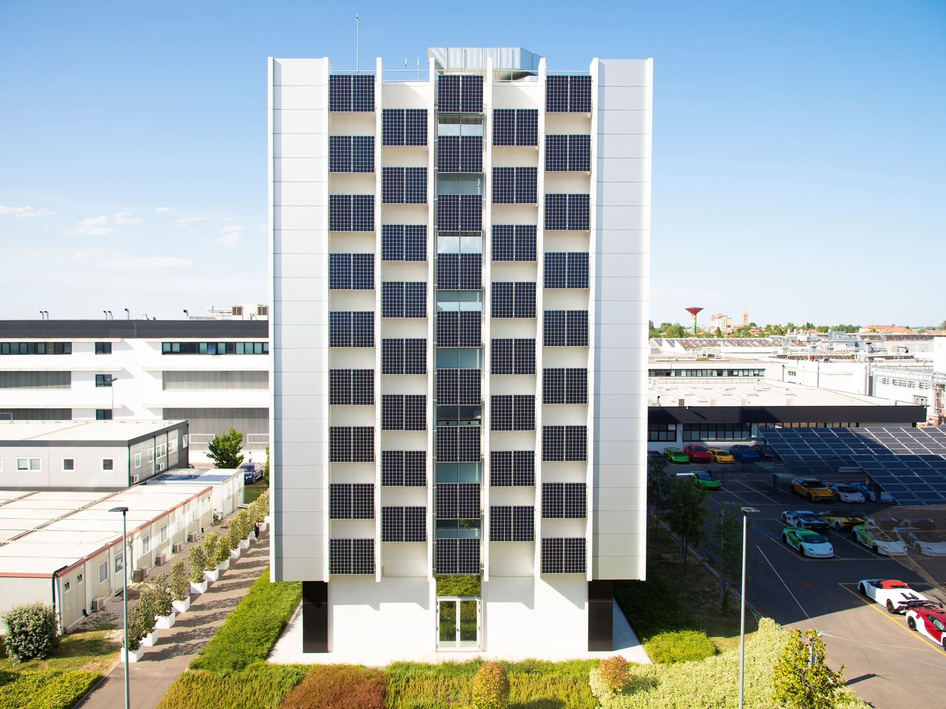 Bees, Biogas, And The Raging Bull: How Lamborghini'S Factory Sustainability Protects Its Performance Future 9 Lamborghini factory building covered in solar panels with colorful lamborghini cars parked in the foreground