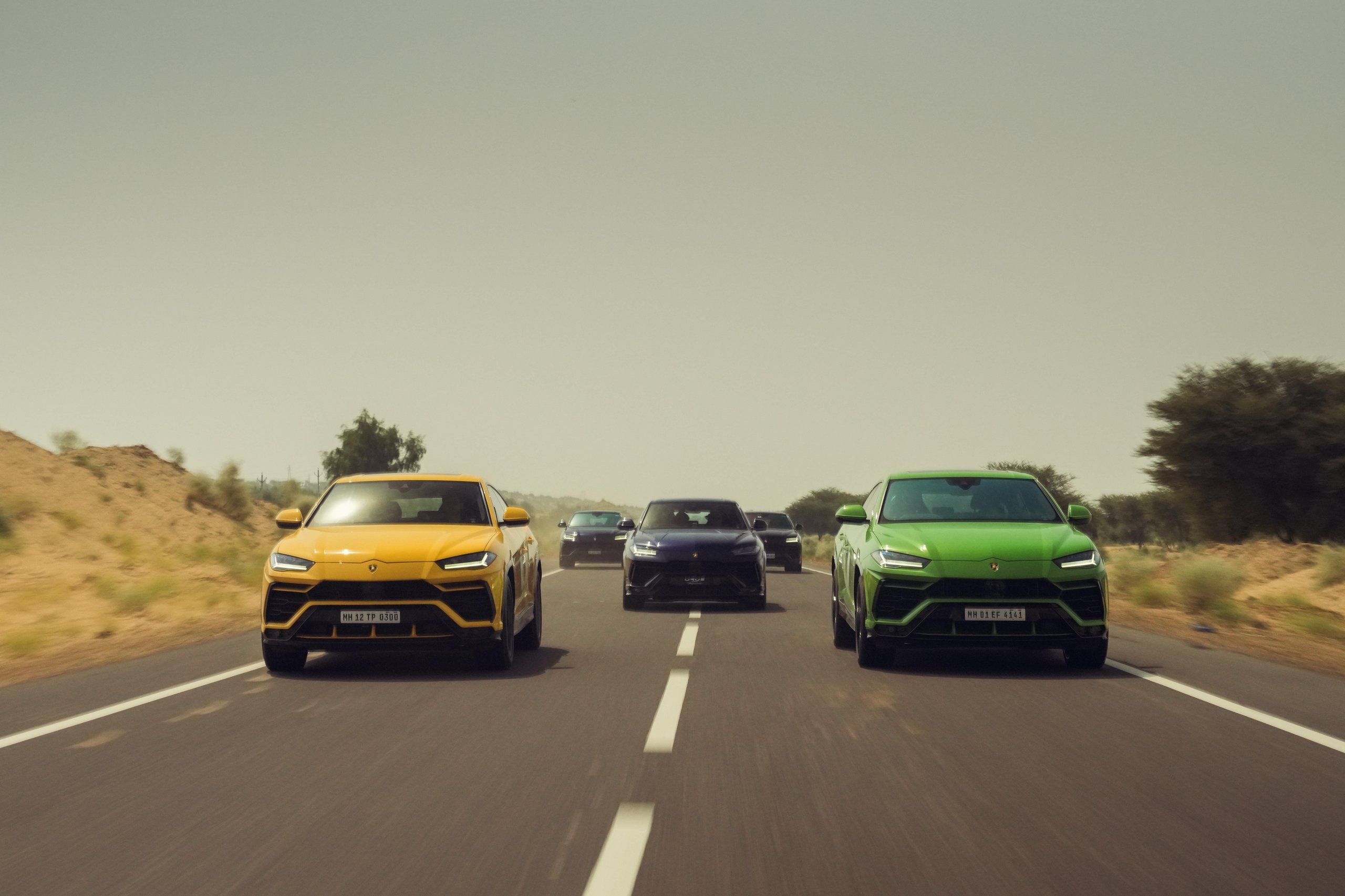 Lamborghini Esperienza Giro India 2023: A Royal 60Th Anniversary Celebration Across Rajasthan 7 Green and yellow lamborghini urus models driving side by side leading a convoy through dry rajasthani landscape