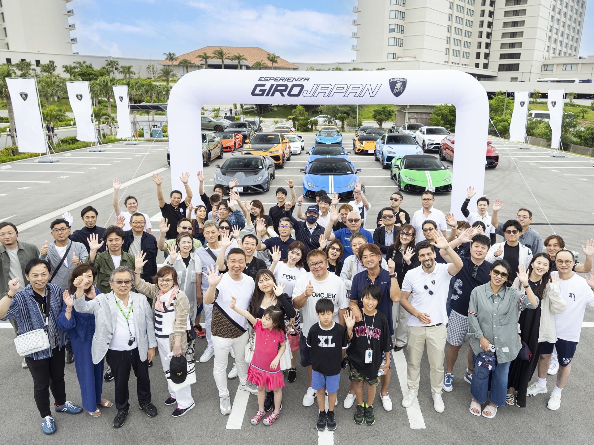 Lamborghini Turned Okinawa Into A Three-Day Supercar Convoy For Giro Japan 2024, With A Revuelto Debut As The Centerpiece 5 Large group of participants posing in front of an inflatable esperienza giro japan archway with lamborghini vehicles parked behind them