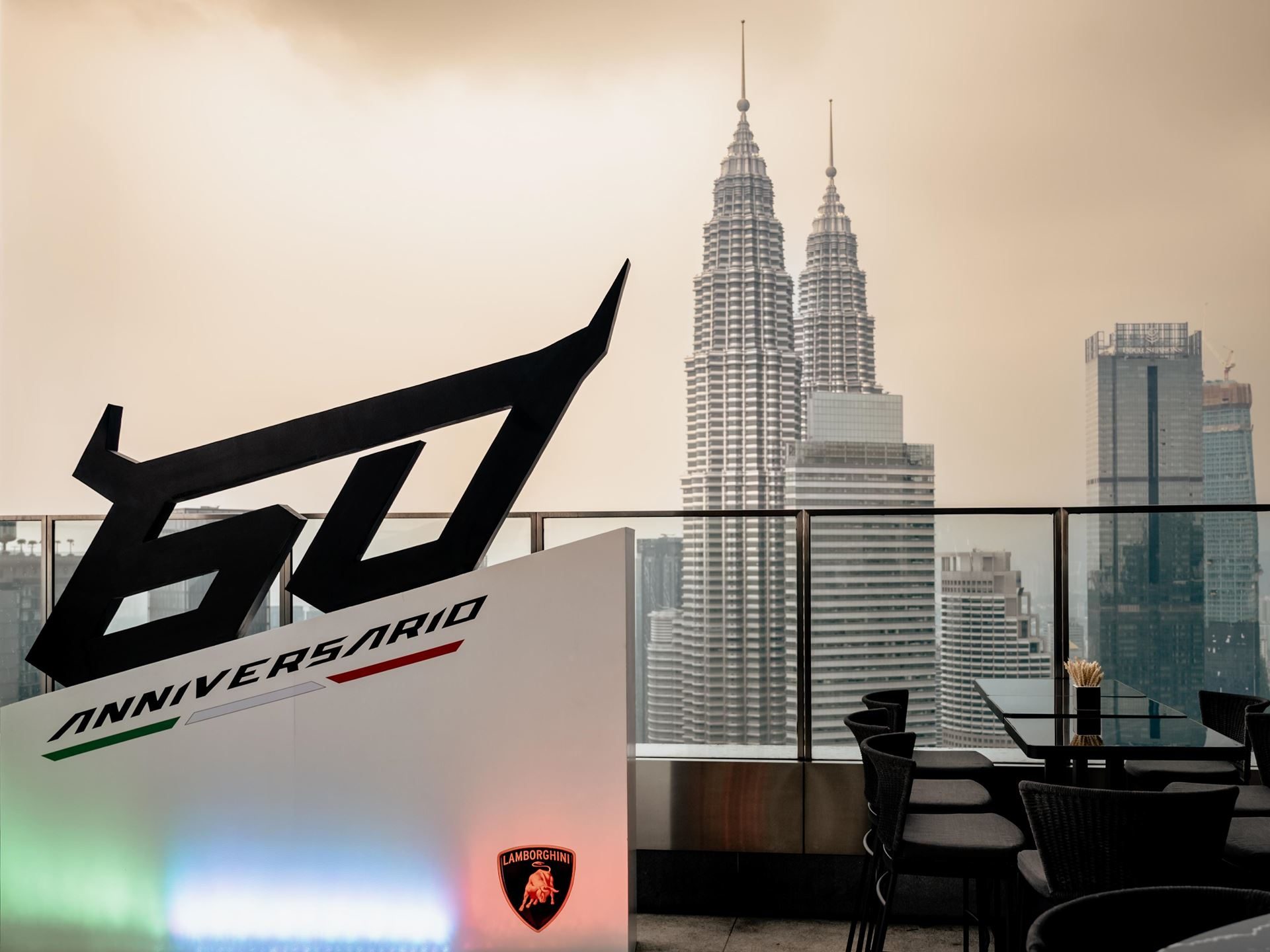 Lamborghini'S First Southeast Asia Esperienza Giro Turned Malaysia Into A Rolling 60Th Birthday Party 11 60 anniversario sign with lamborghini logo on a rooftop terrace overlooking the kuala lumpur skyline and petronas twin towers