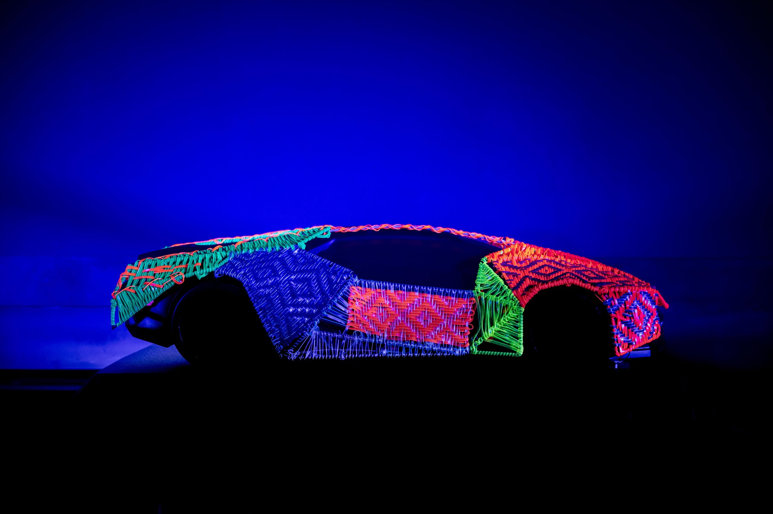 Lamborghini'S First Southeast Asia Esperienza Giro Turned Malaysia Into A Rolling 60Th Birthday Party 7 Dark silhouette of a car illuminated by vibrant multi-colored geometric light patterns in a dark studio setting