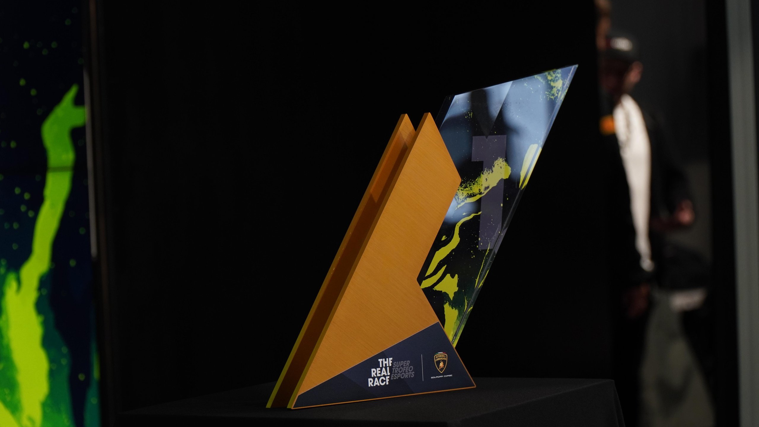 Dario Iemmulo Wins Lamborghini'S European Esports Finals, Earns Shot At Factory Driver Seat 3 Close-up of the real race trophy featuring orange and blue-yellow abstract patterns against a dark background