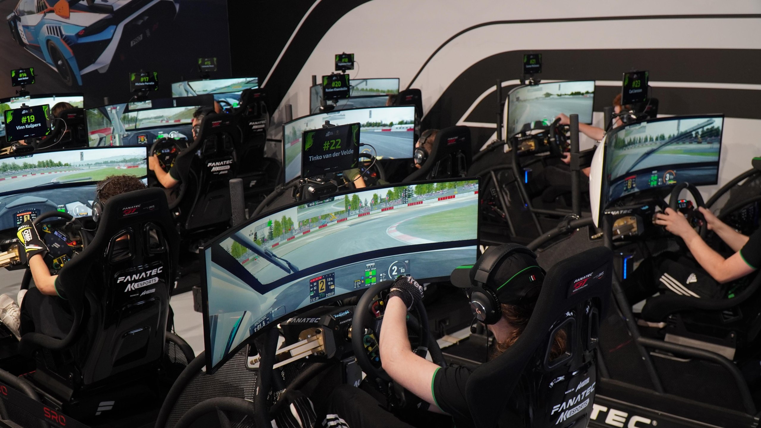 Dario Iemmulo Wins Lamborghini'S European Esports Finals, Earns Shot At Factory Driver Seat 7 Overhead view of multiple participants racing on simulators with curved screens displaying virtual race tracks at the fanatec arena