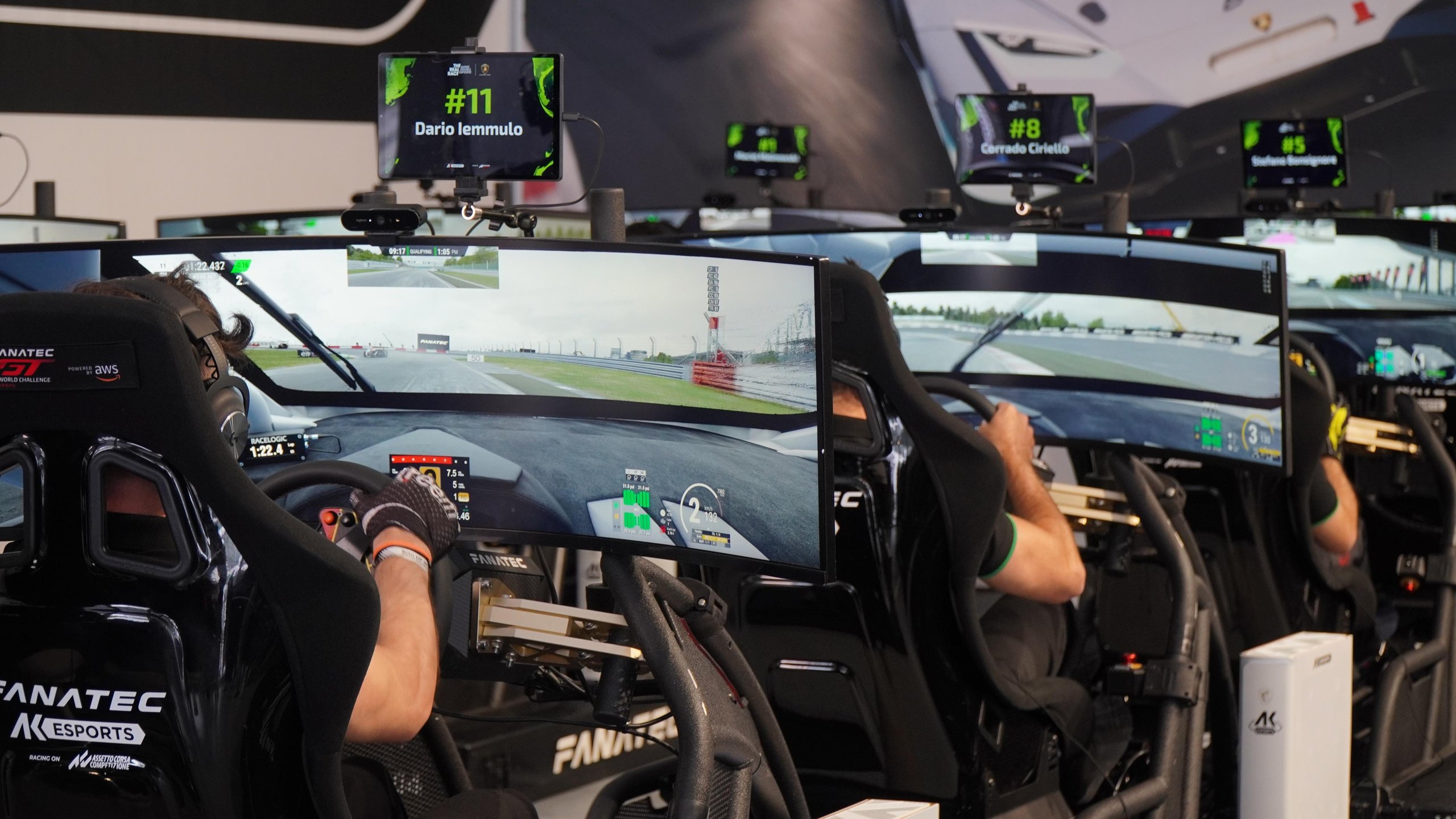 Dario Iemmulo Wins Lamborghini'S European Esports Finals, Earns Shot At Factory Driver Seat 9 Rear view of several participants racing on simulators with screens showing virtual race tracks during the real race european finals