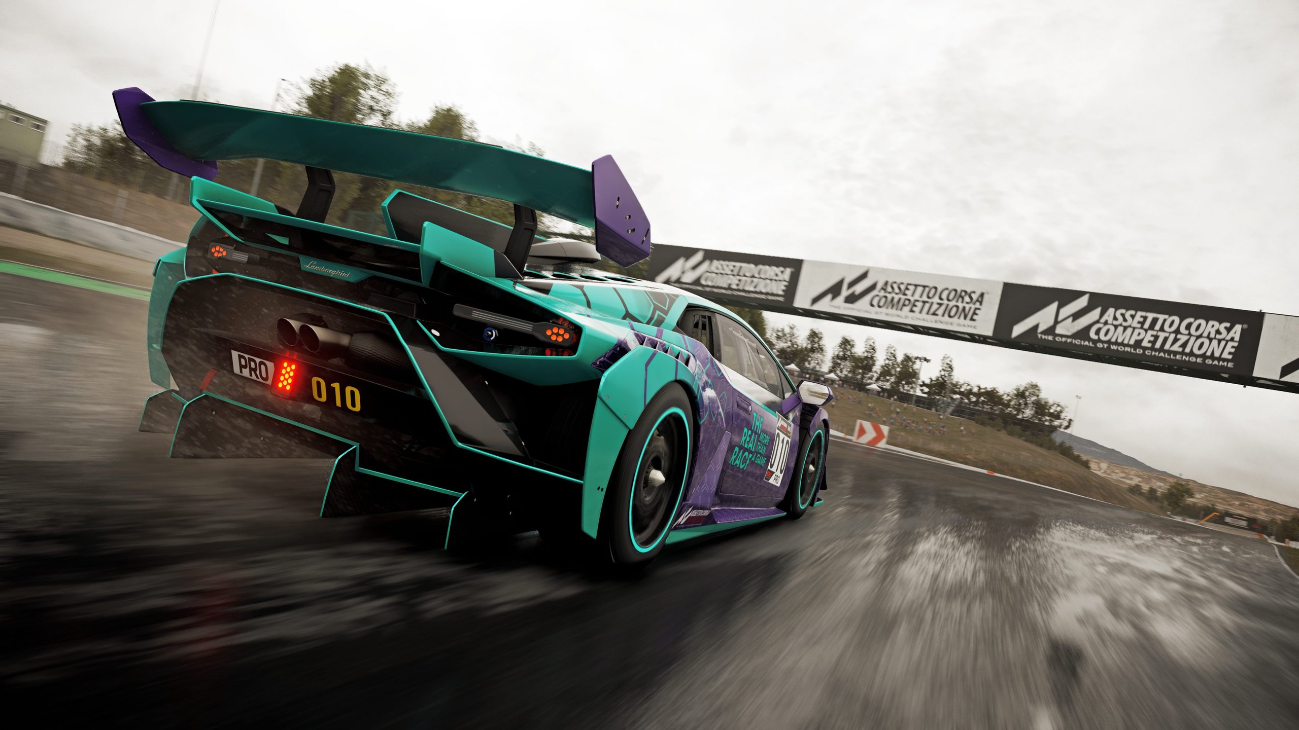 Lamborghini'S 'The Real Race' Offers Sim Racers A Factory Esports Seat, And That Changes The Talent Pipeline 3 Purple and teal lamborghini huracán gt3 evo race car with hexagonal livery speeding through a wet turn on a race track