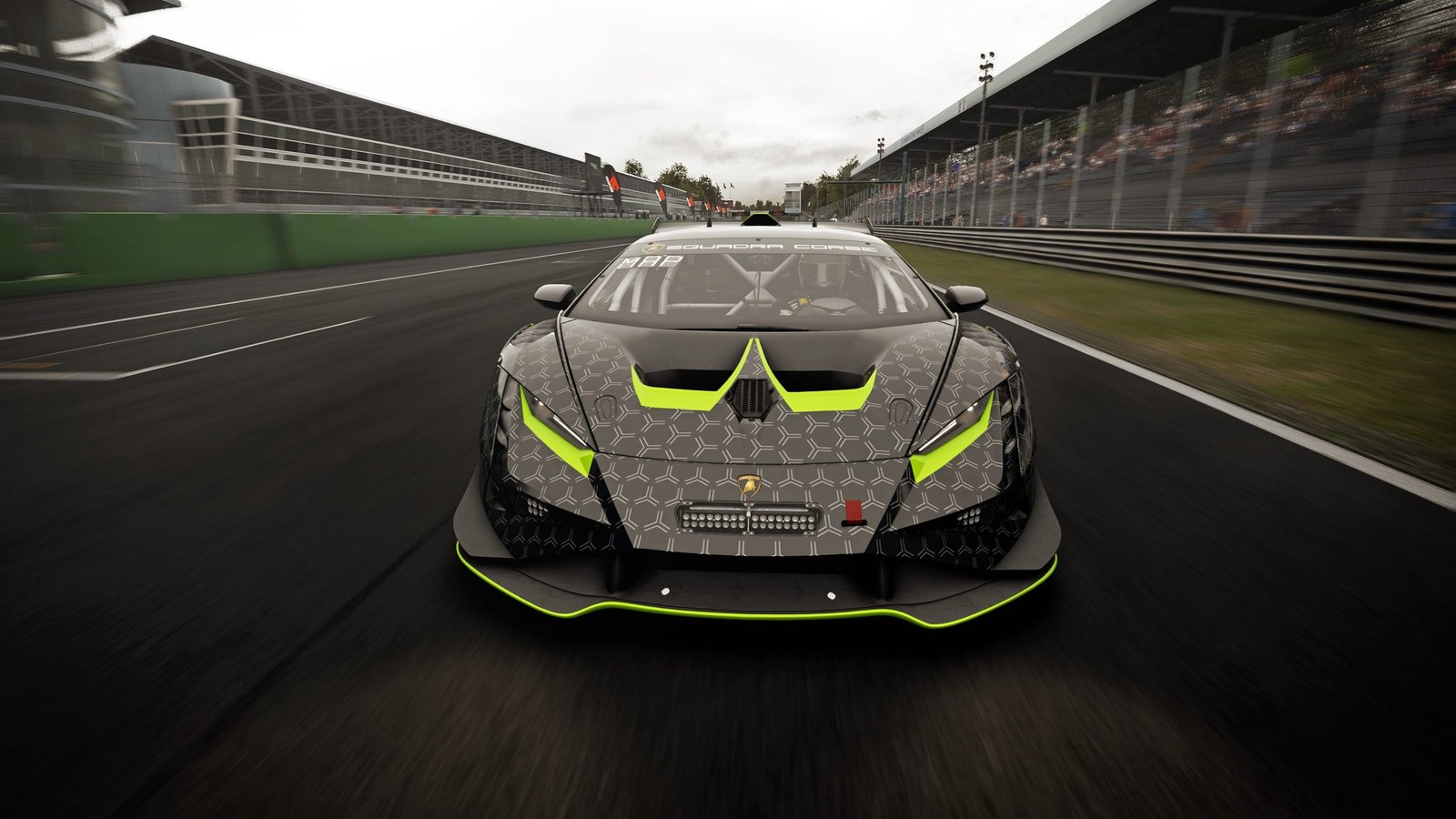 Black and lime green Lamborghini Huracán GT3 EVO race car with hexagonal livery approaching on a sunlit race track