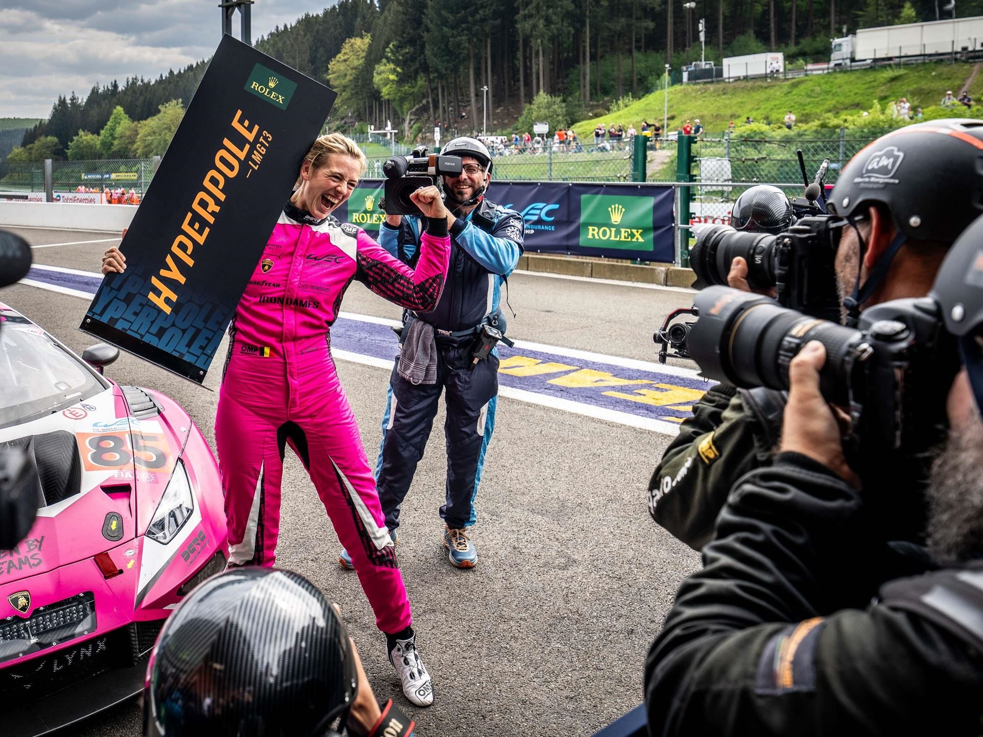 Lamborghini'S First Wec Podium Came With A 15-Place Climb And A Hypercar Heartbreak At Spa 5 A female driver in a pink racing suit holds a hyperpole board next to the no. 85 iron dames lamborghini huracán gt3 evo2