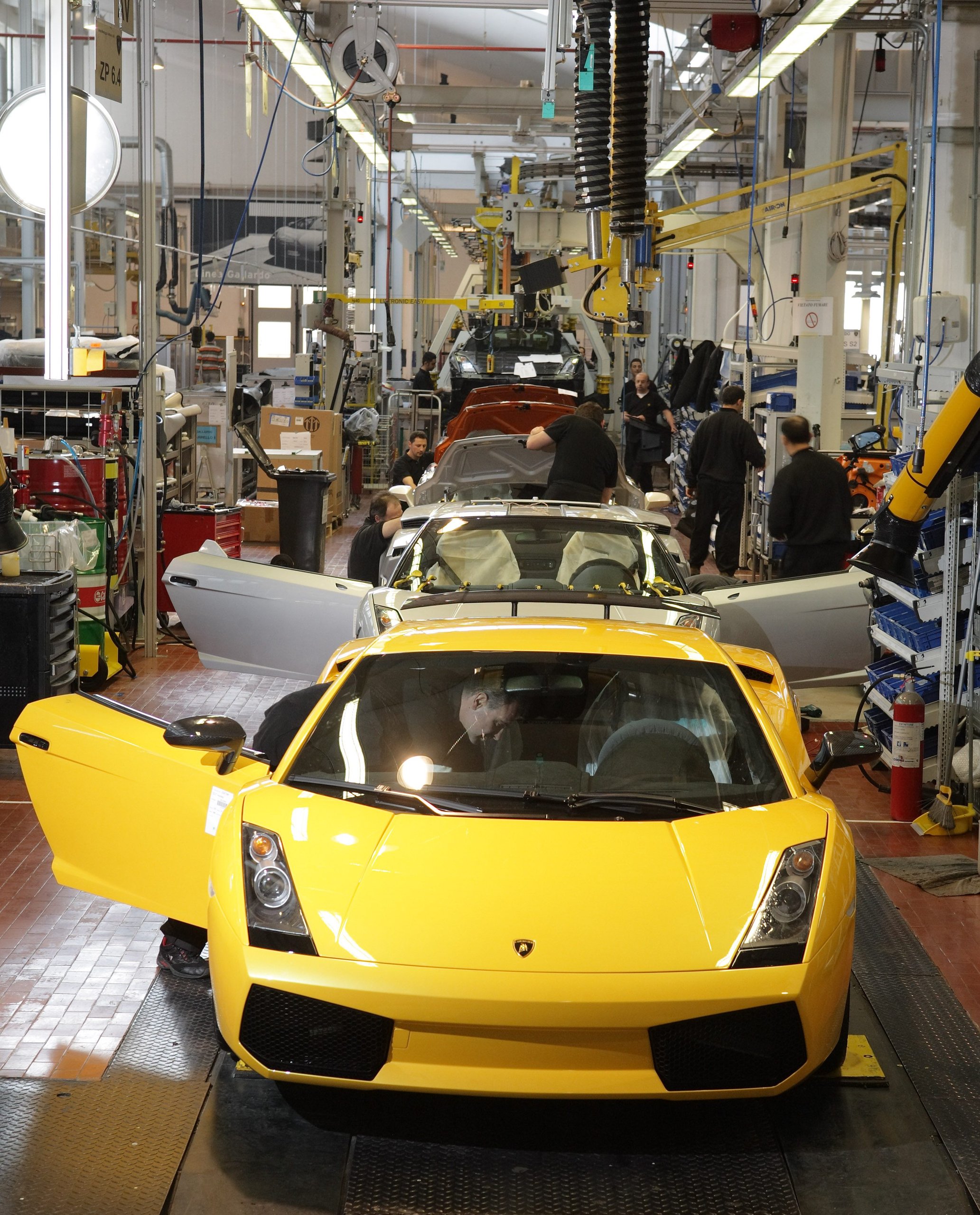 Yellow Lamborghini Gallardo on the assembly line at Sant'Agata Bolognese with workers performing tasks