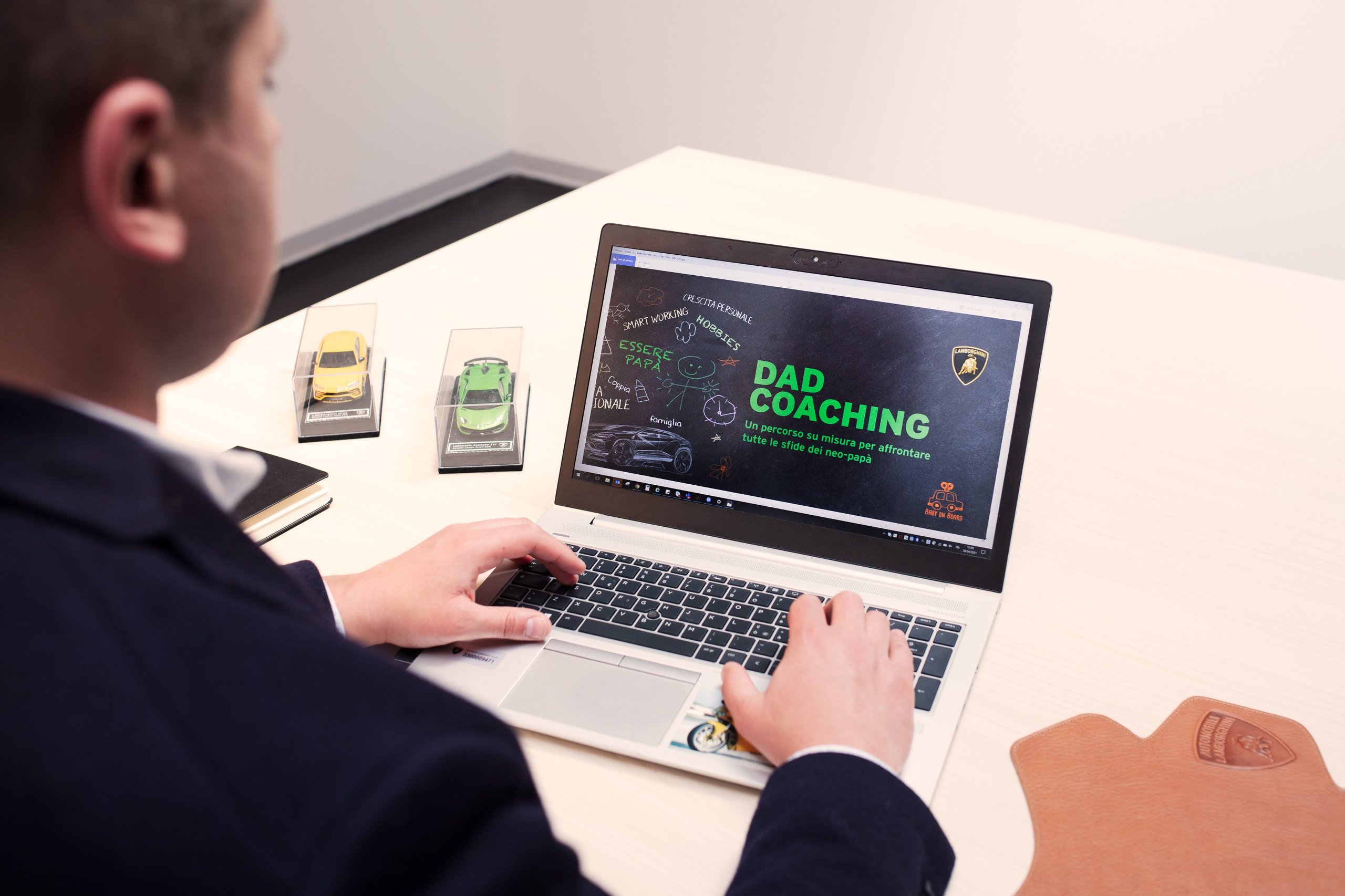 Lamborghini'S Gender Equality Certification Puts Sant'Agata Ahead Of Most Rivals, But What Does It Actually Mean? 5 Laptop screen displaying lamborghini dad coaching program with miniature lamborghini models on desk