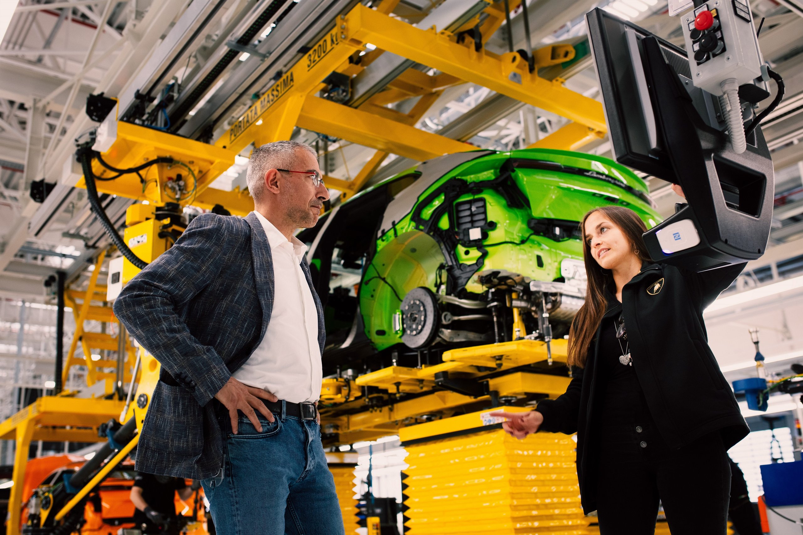 Lamborghini'S Gender Equality Certification Puts Sant'Agata Ahead Of Most Rivals, But What Does It Actually Mean? 11 Male and female lamborghini employees discussing production details on the assembly line while reviewing a diagnostic monitor