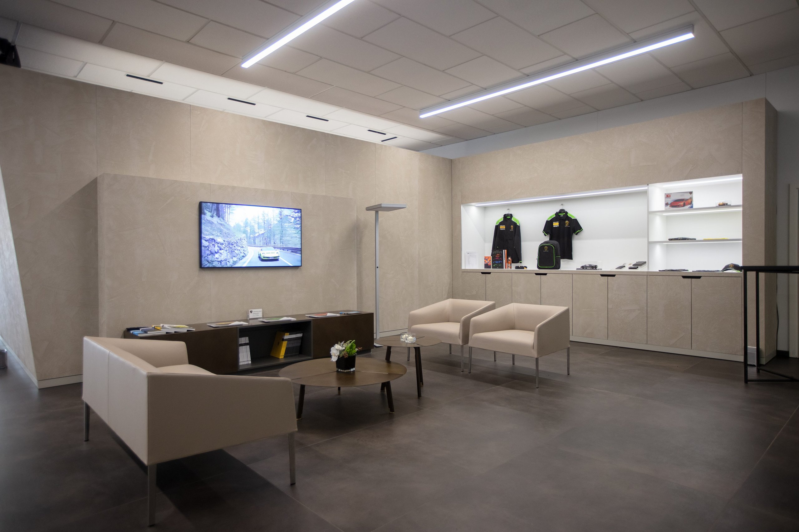 Lamborghini Geneva Celebrates 20 Years With A Showroom Built For The Brand'S Next Chapter 7 Lamborghini geneva showroom lounge area with large screen, comfortable seating, and branded merchandise display
