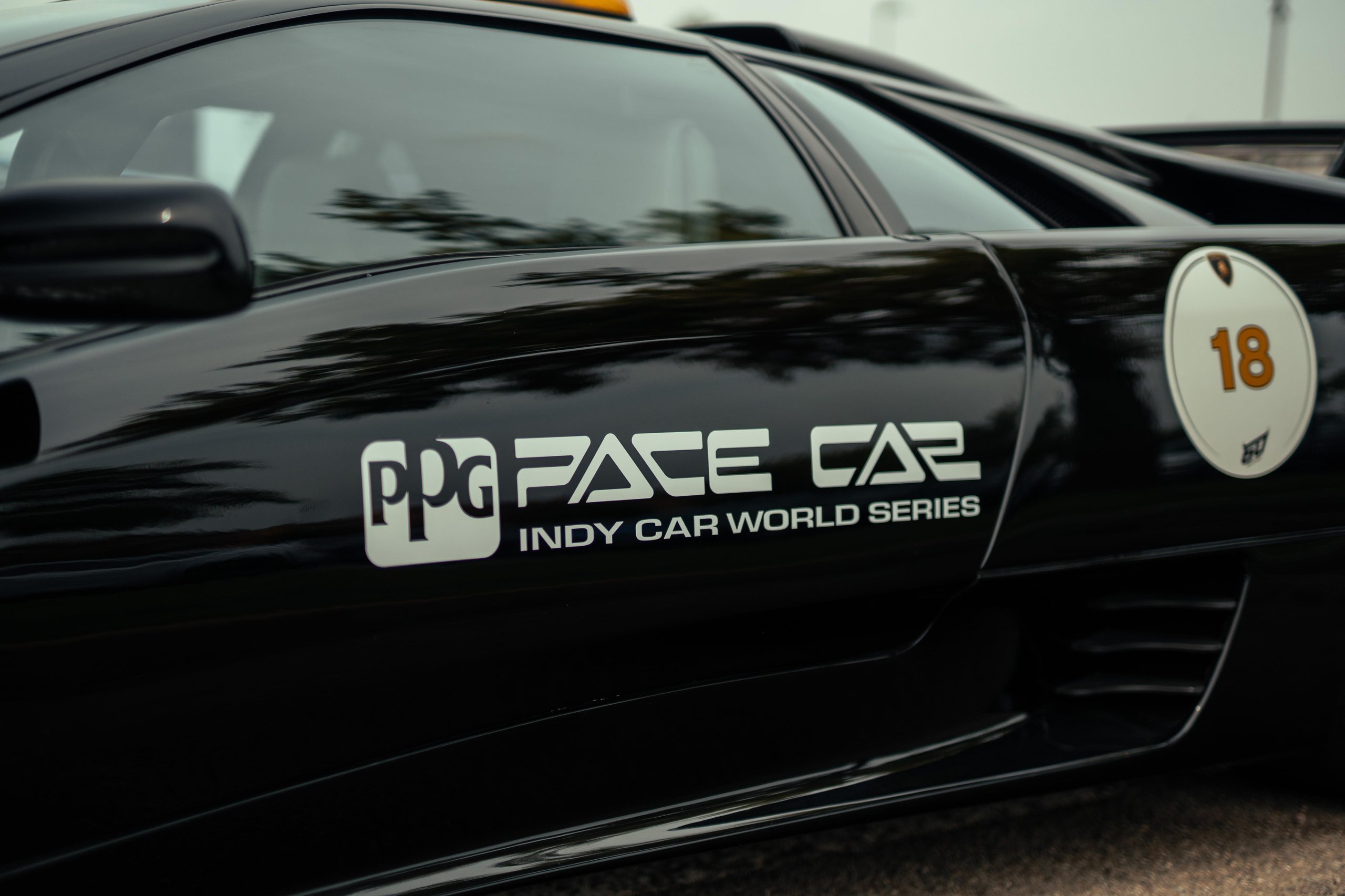 How Lamborghini Turned Italy'S Roads Into A Rolling Museum For Its 60Th Anniversary 11 Close-up of the ppg pace car indy car world series decal and number 18 roundel on the side of the black lamborghini diablo vt