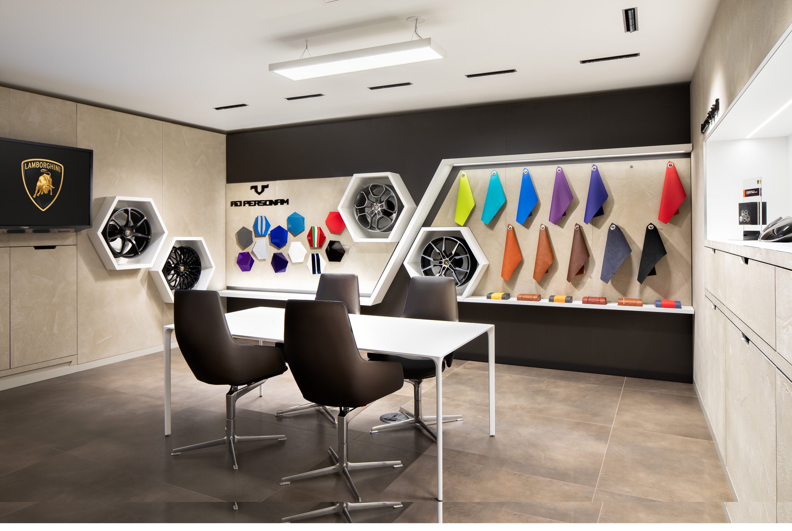 Lamborghini Greenwich Opens With A Proper Ad Personam Studio, And That Matters More Than The Ribbon Cutting 5 Interior of the lamborghini greenwich ad personam studio showing wheel designs, paint samples, upholstery swatches, and a consultation table