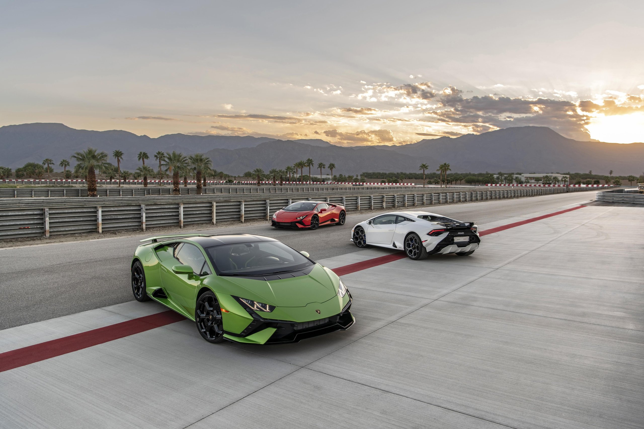 Lamborghini'S 35.7% Profit Margin In Q1 2023 Tells A Bigger Story Than Record Sales Alone 9 Three lamborghini huracán models in green, red, and white parked on a race track at sunset with mountains in the background