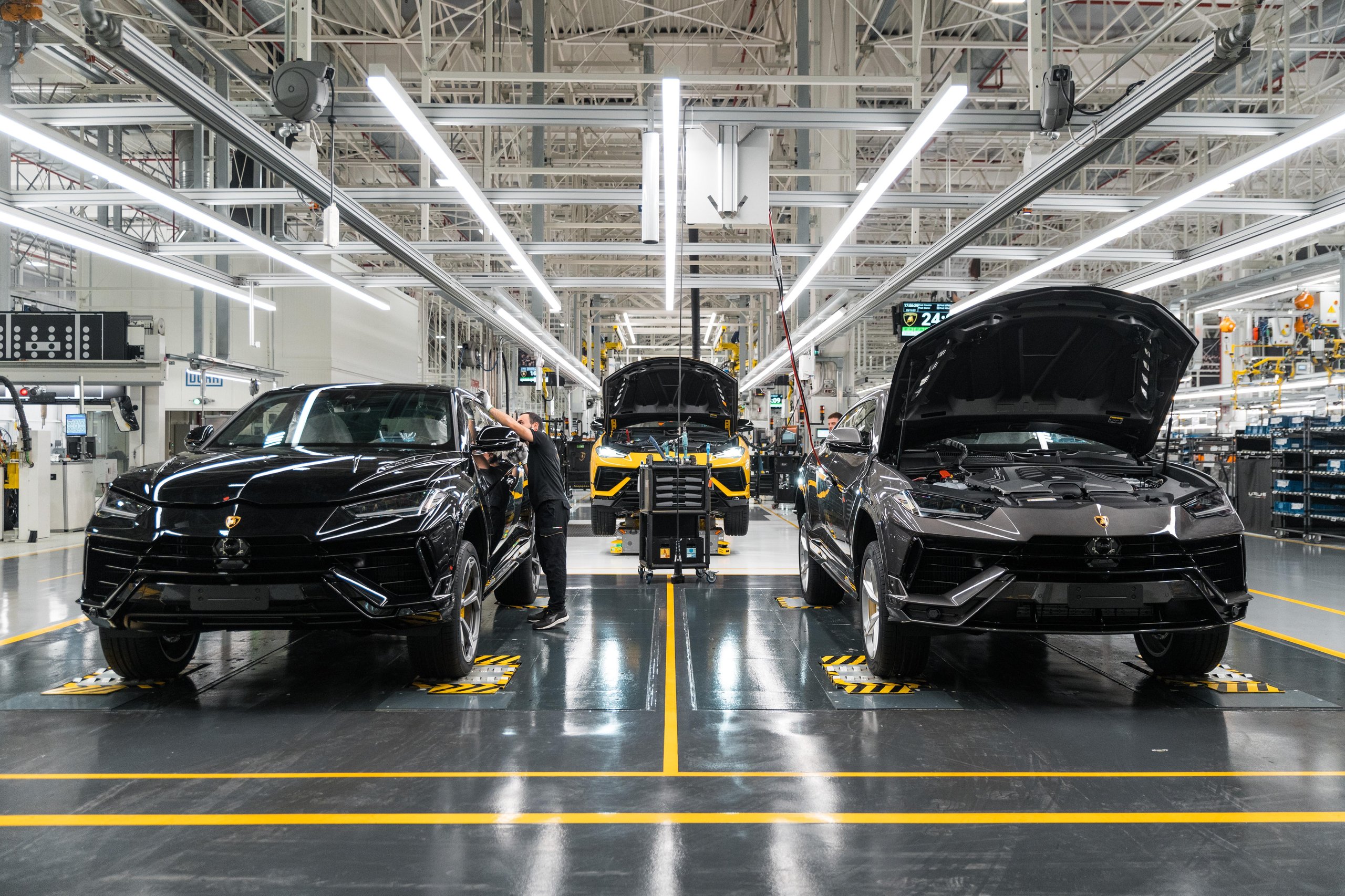 Lamborghini'S 35.7% Profit Margin In Q1 2023 Tells A Bigger Story Than Record Sales Alone 5 Two lamborghini urus suvs on the assembly line in a brightly lit factory with workers attending to them
