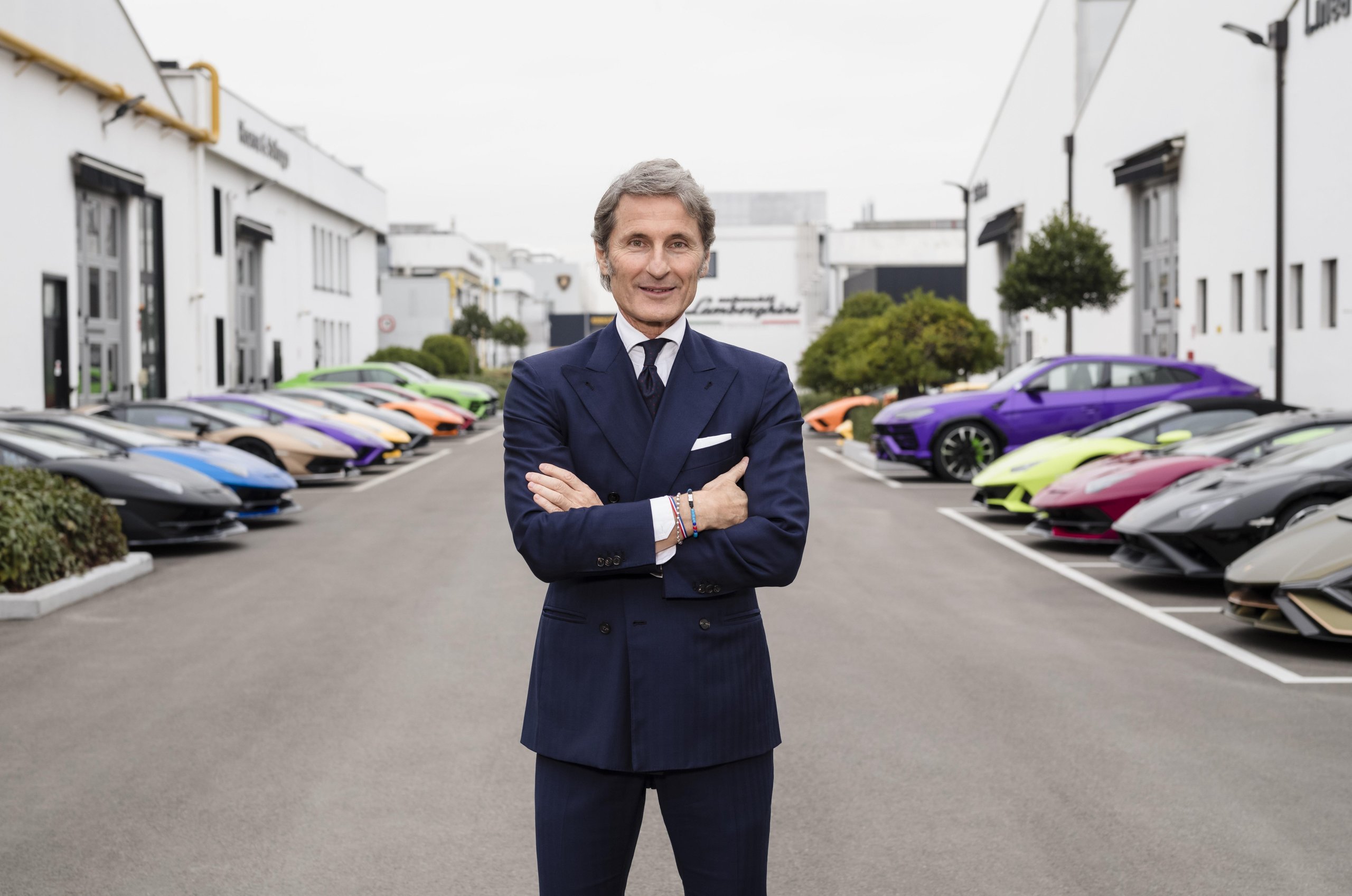 Lamborghini'S 35.7% Profit Margin In Q1 2023 Tells A Bigger Story Than Record Sales Alone 7 Stephan winkelmann standing with arms crossed in front of the lamborghini factory, flanked by colorful lamborghini vehicles