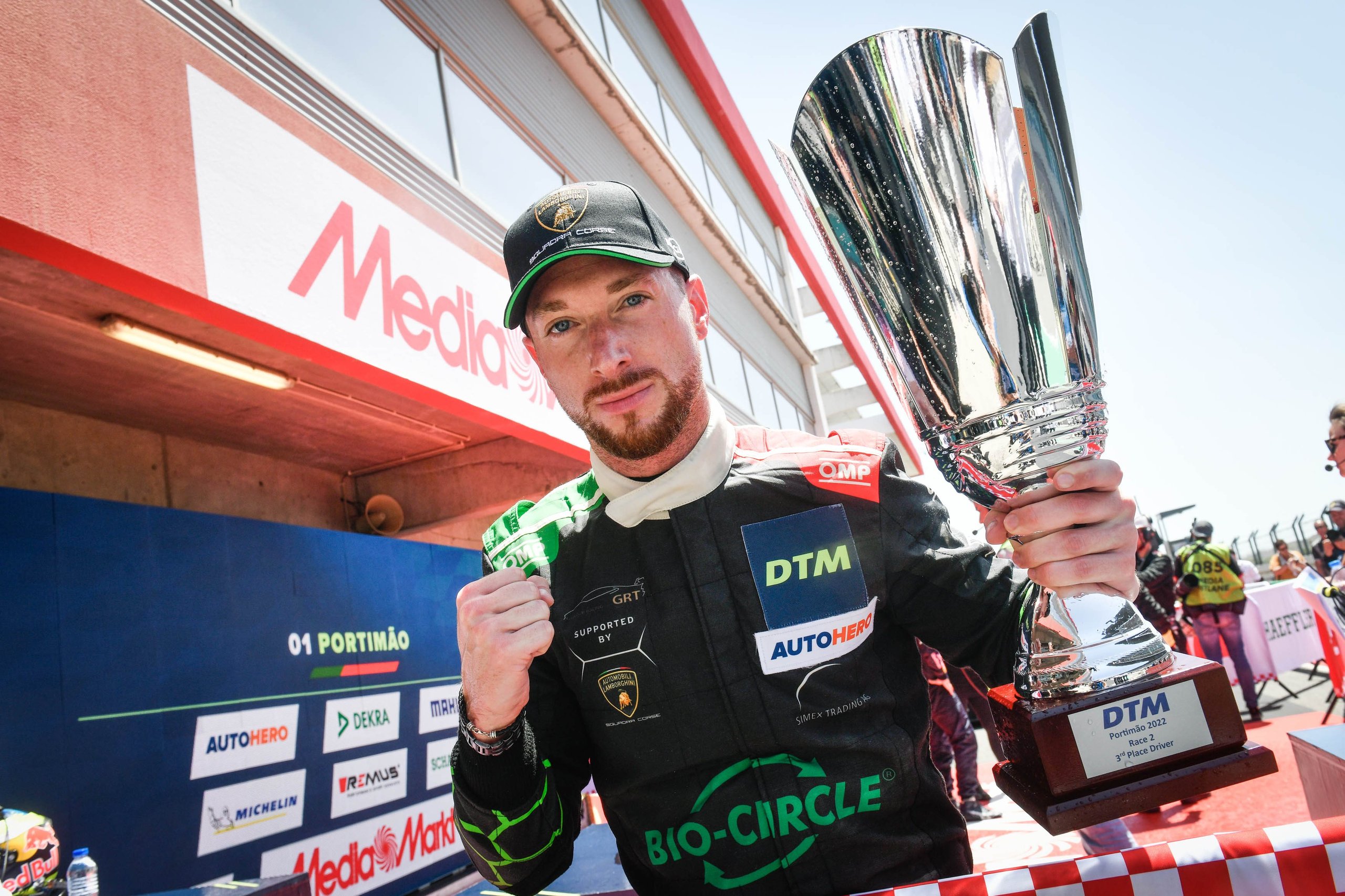 Oregon Team'S Clean Sweep At Estoril And Bortolotti'S Dtm Lead Signal The Huracán Gt3 Evo Still Owns Gt Racing 5 Mirko bortolotti in green and black grasser racing team suit holding a silver trophy after his dtm podium finish at portimão