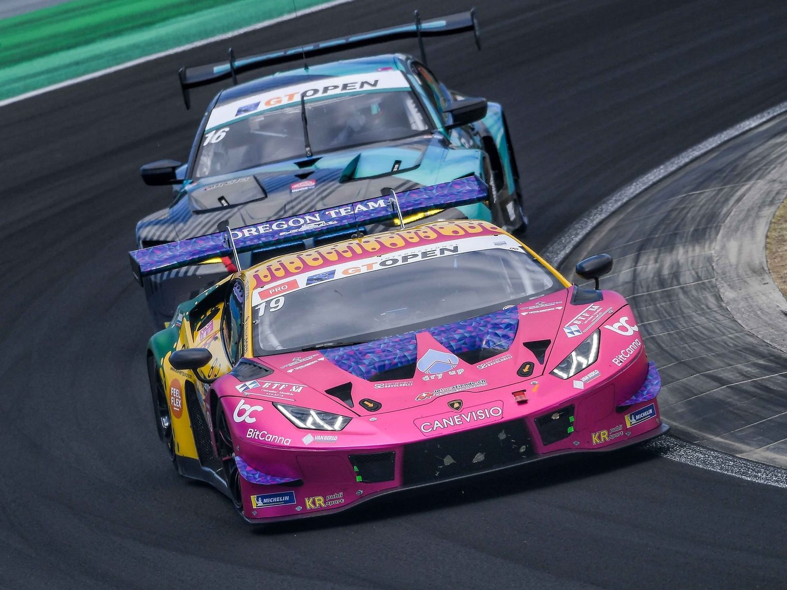 Oregon Team's number 19 Lamborghini Huracán GT3 EVO in pink and yellow livery leading a competitor on the Hungaroring circuit