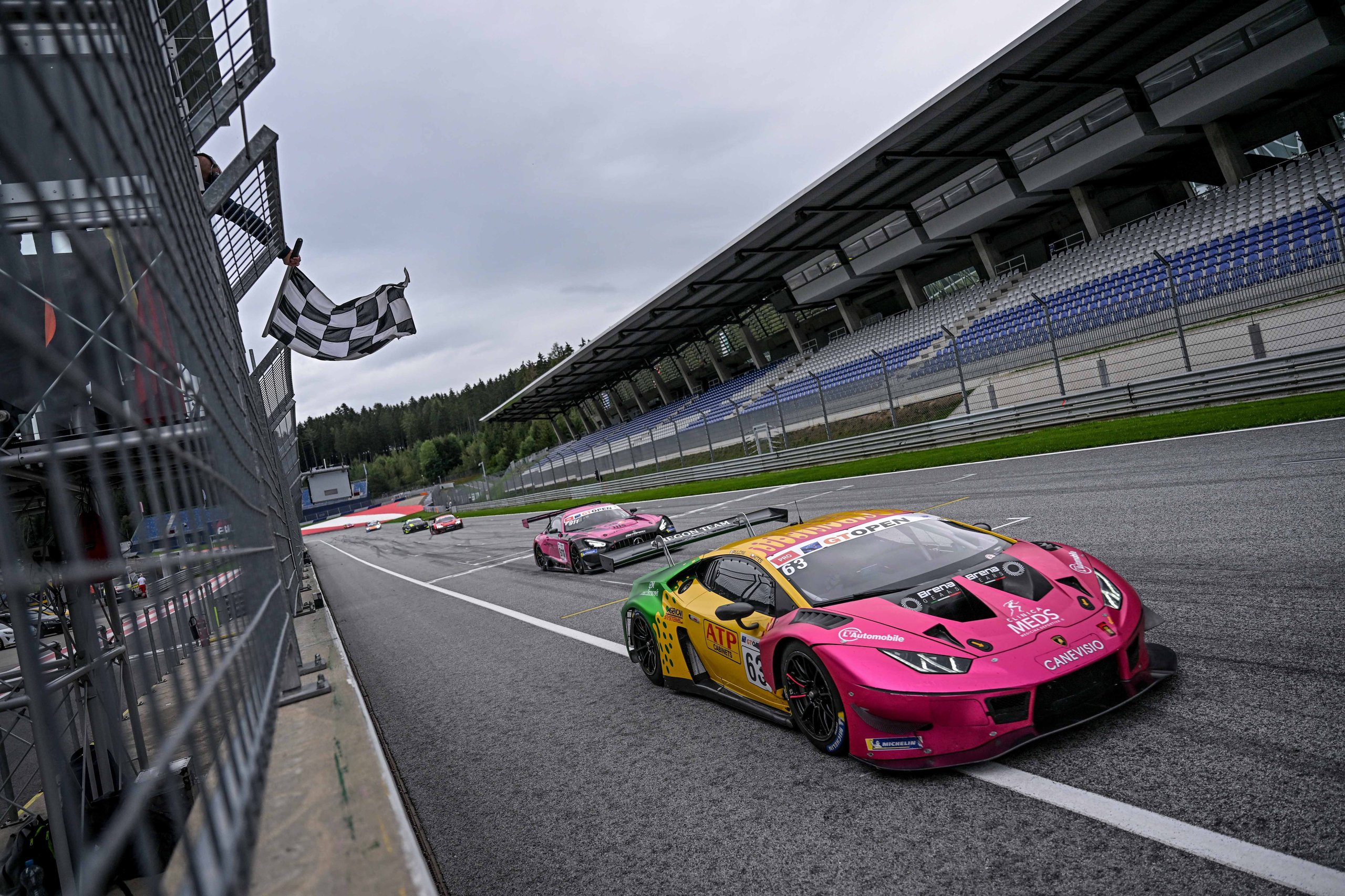 Oregon Team'S Red Bull Ring Sweep Put Two Huracán Gt3 Evos At The Top Of The Gt Open Standings, Then The Real Fight Began 3 Two lamborghini huracán gt3 evo race cars crossing the finish line under the checkered flag at the red bull ring