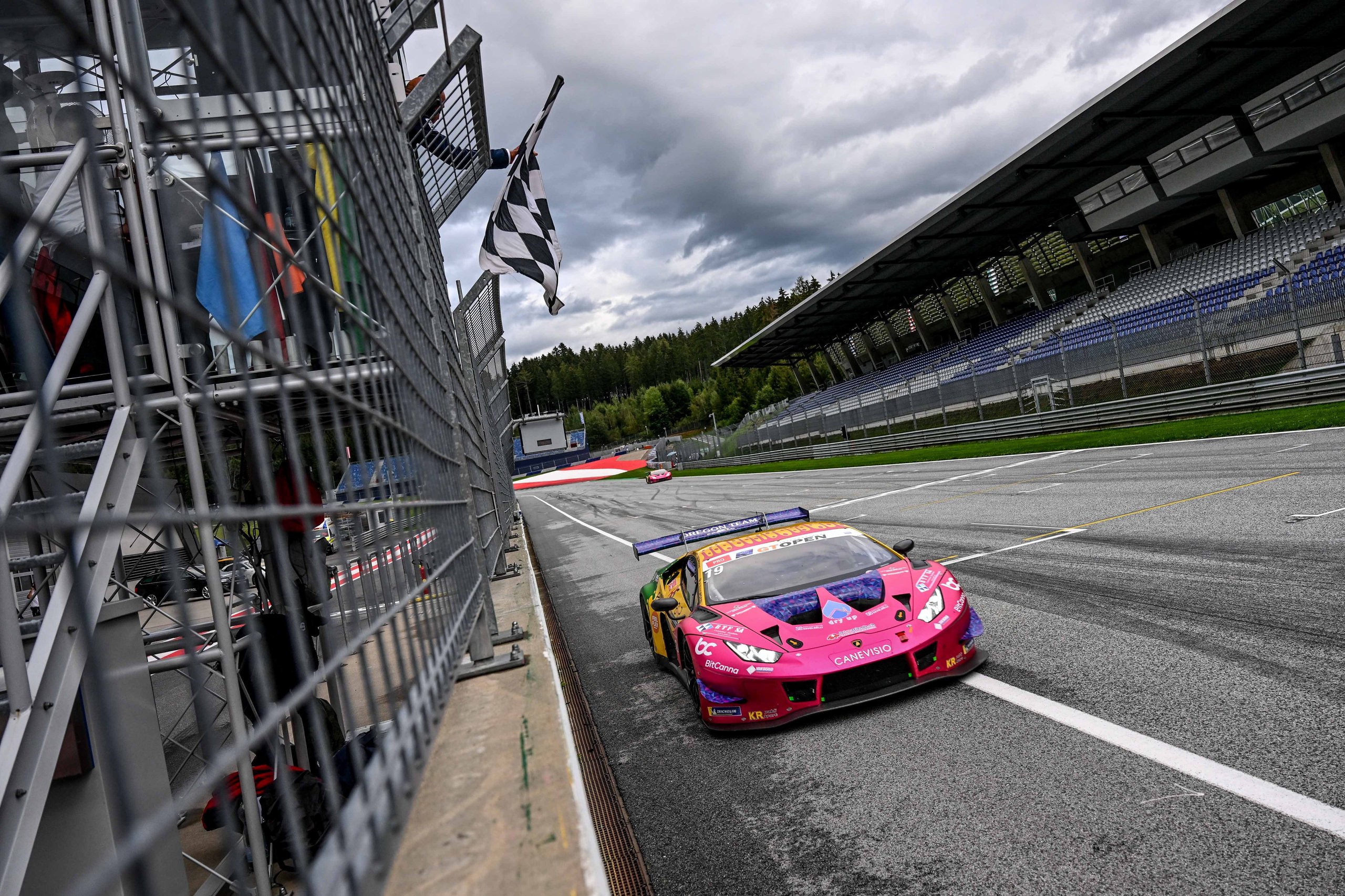 Oregon Team'S Red Bull Ring Sweep Put Two Huracán Gt3 Evos At The Top Of The Gt Open Standings, Then The Real Fight Began 5 Lamborghini huracán gt3 evo crossing the finish line under a checkered flag on a cloudy day at the red bull ring