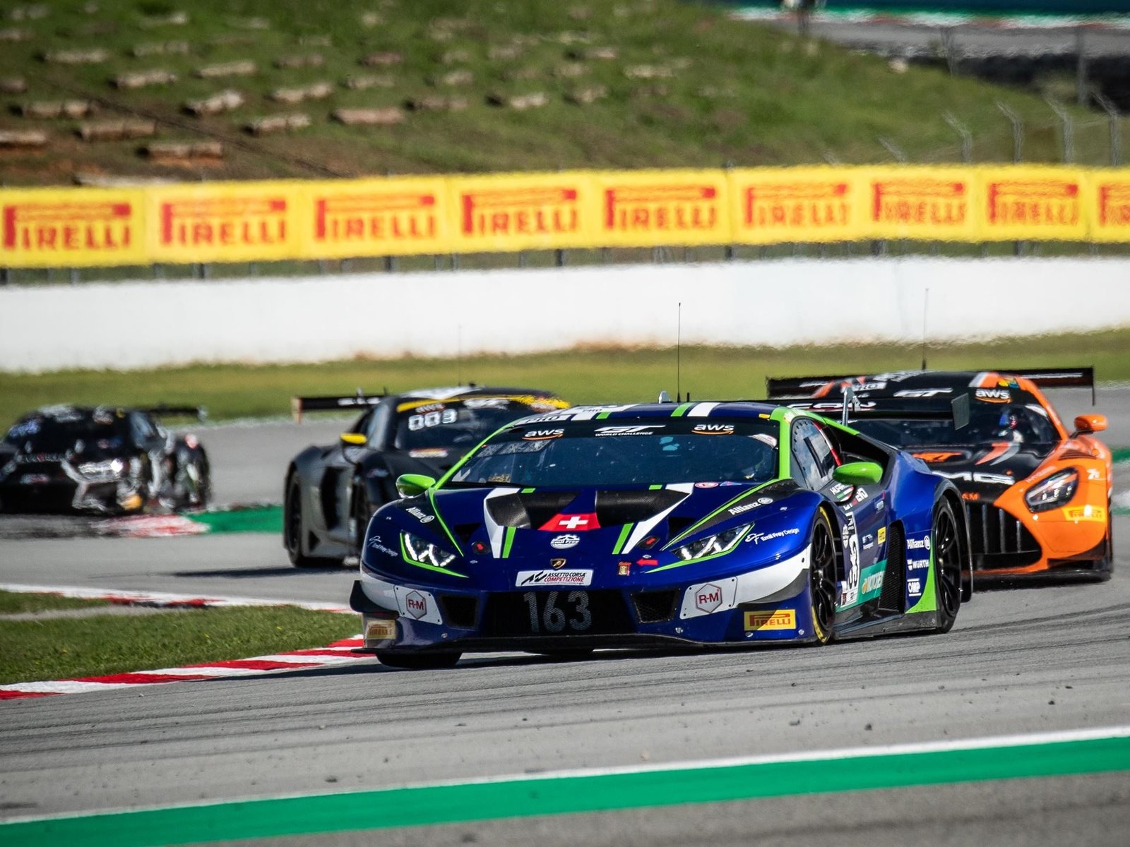 Lamborghini Huracán GT3 Evo number 163 in blue and green Emil Frey Racing livery leading on track at Barcelona