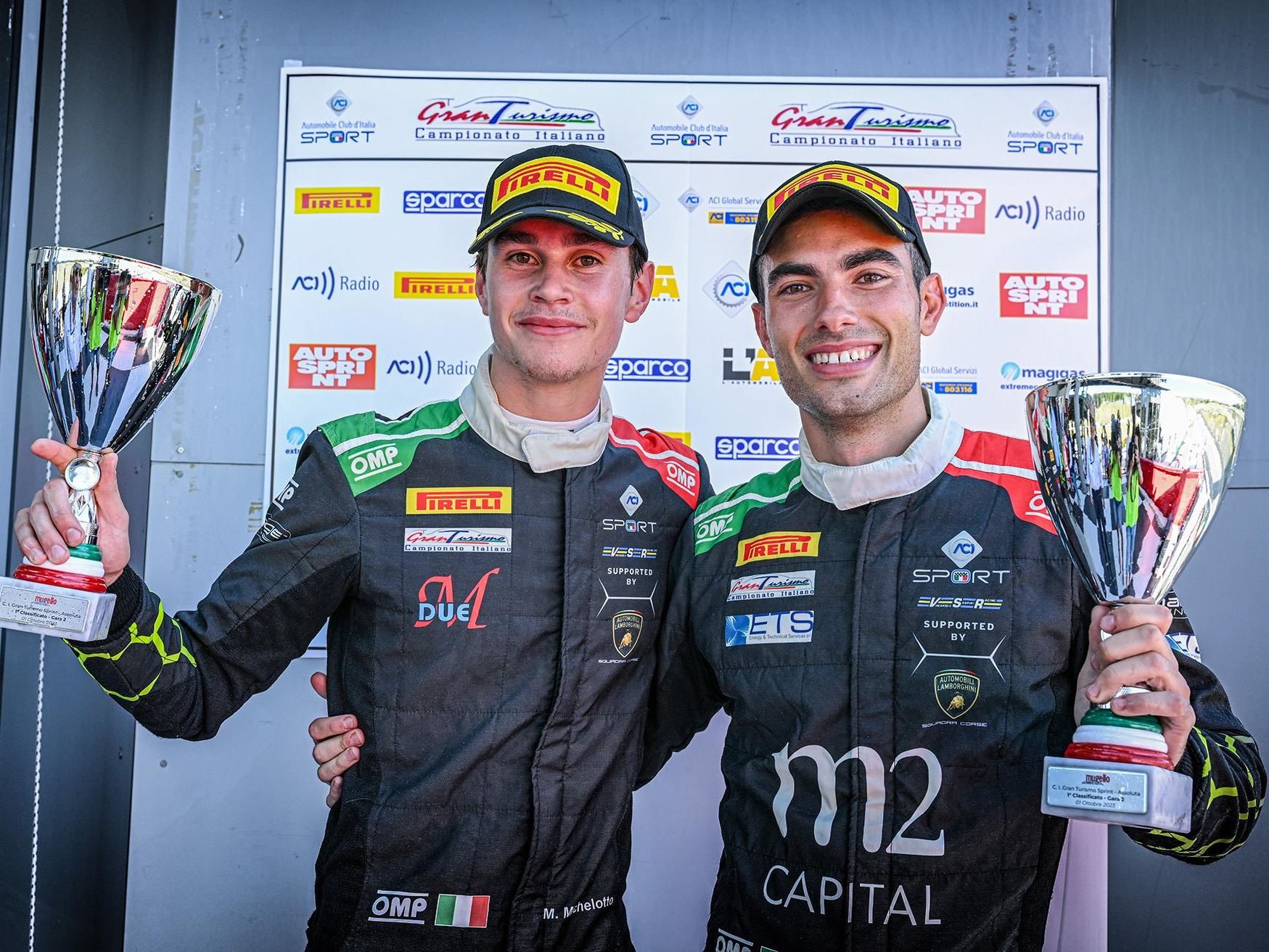 Huracán Gt3 Evo2 Clinches Silver Cup Title At Barcelona As Lamborghini'S V10 Racer Writes Its Final Championship Chapters 5 Two racing drivers in racing suits standing on a podium holding trophies and smiling after a championship victory