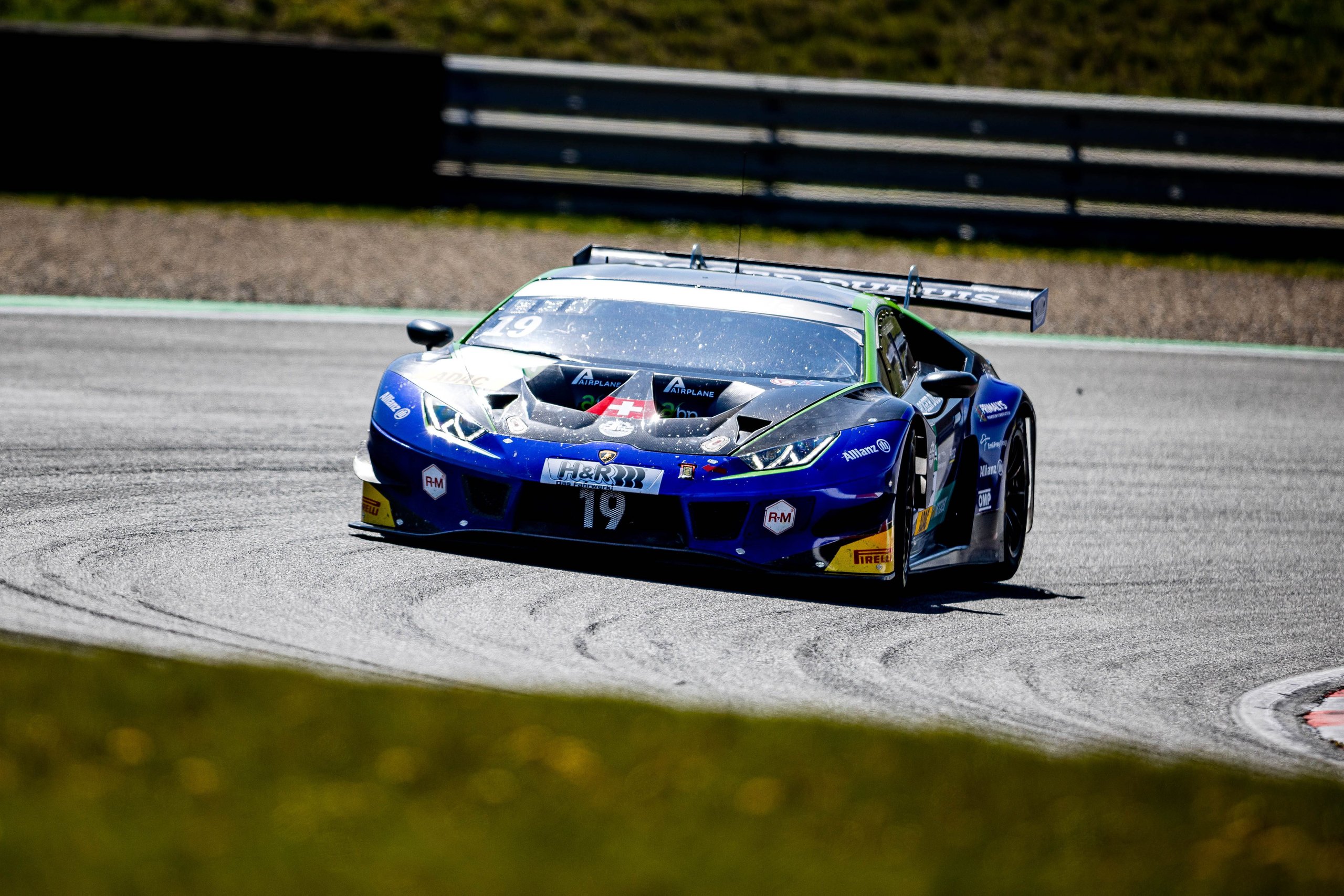 Di Folco'S Solo Monza Victory Proves The Huracán Gt3 Evo Still Bites Hard 7 Blue and black lamborghini huracán gt3 evo with green accents racing through a corner on a sunny track