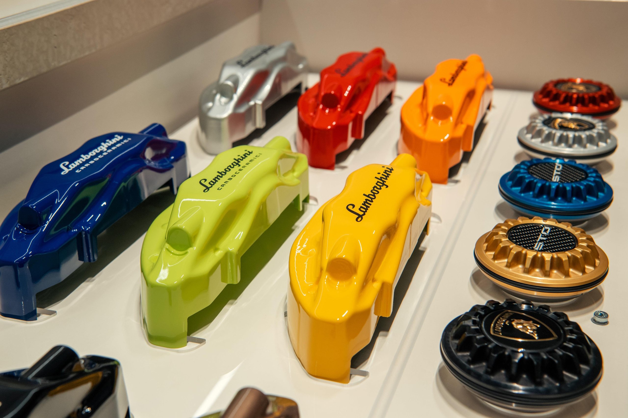 Lamborghini Plants Its Flag In Vietnam With A Ho Chi Minh City Showroom That Doubles As A 60Th Anniversary Statement 15 Display of colorful lamborghini brake caliper and wheel cap samples showcasing ad personam customization options at the ho chi minh city dealership