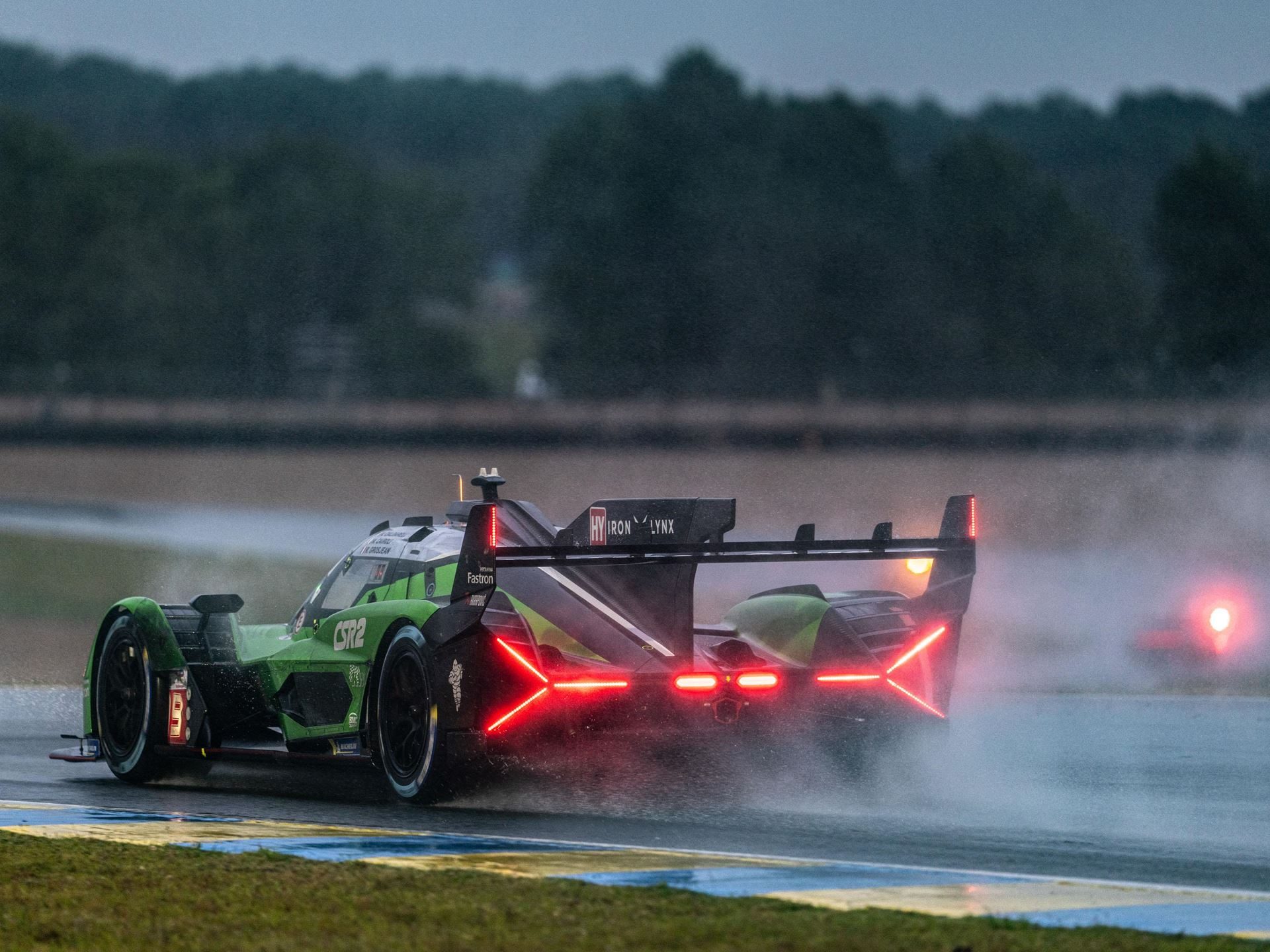 Lamborghini Iron Lynx Brings Track Knowledge And Unchanged Crew To Cota After Bruising Brazil Round 3 Lamborghini sc63 racing on a wet track with illuminated red taillights and spray behind the car
