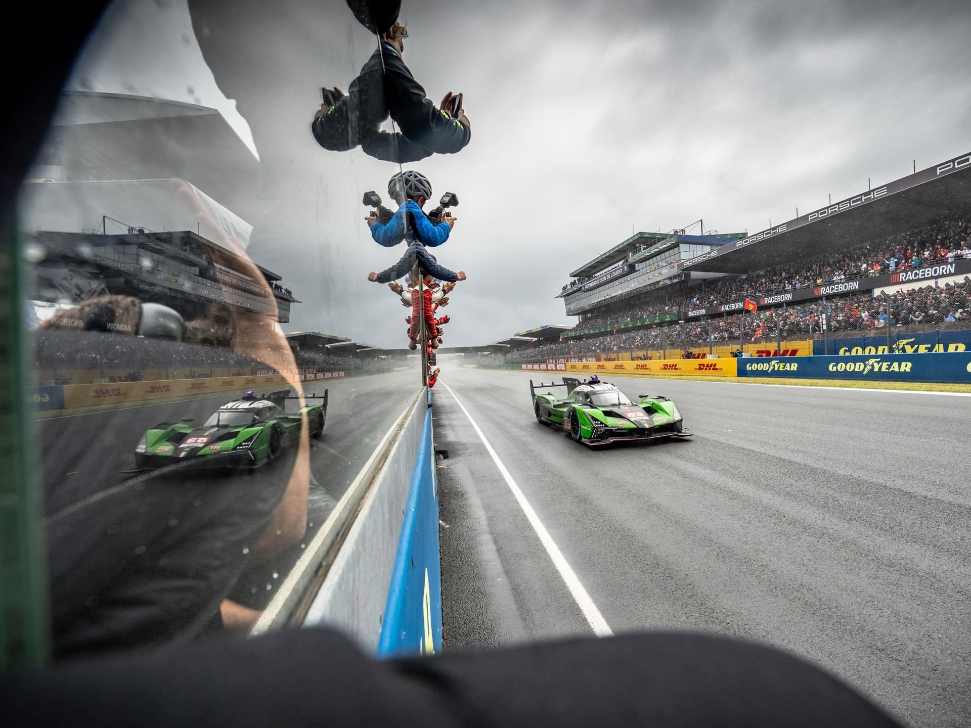 Lamborghini Iron Lynx Brings Track Knowledge And Unchanged Crew To Cota After Bruising Brazil Round 7 Lamborghini sc63 on track viewed through a glass barrier reflection with spectators in the grandstands