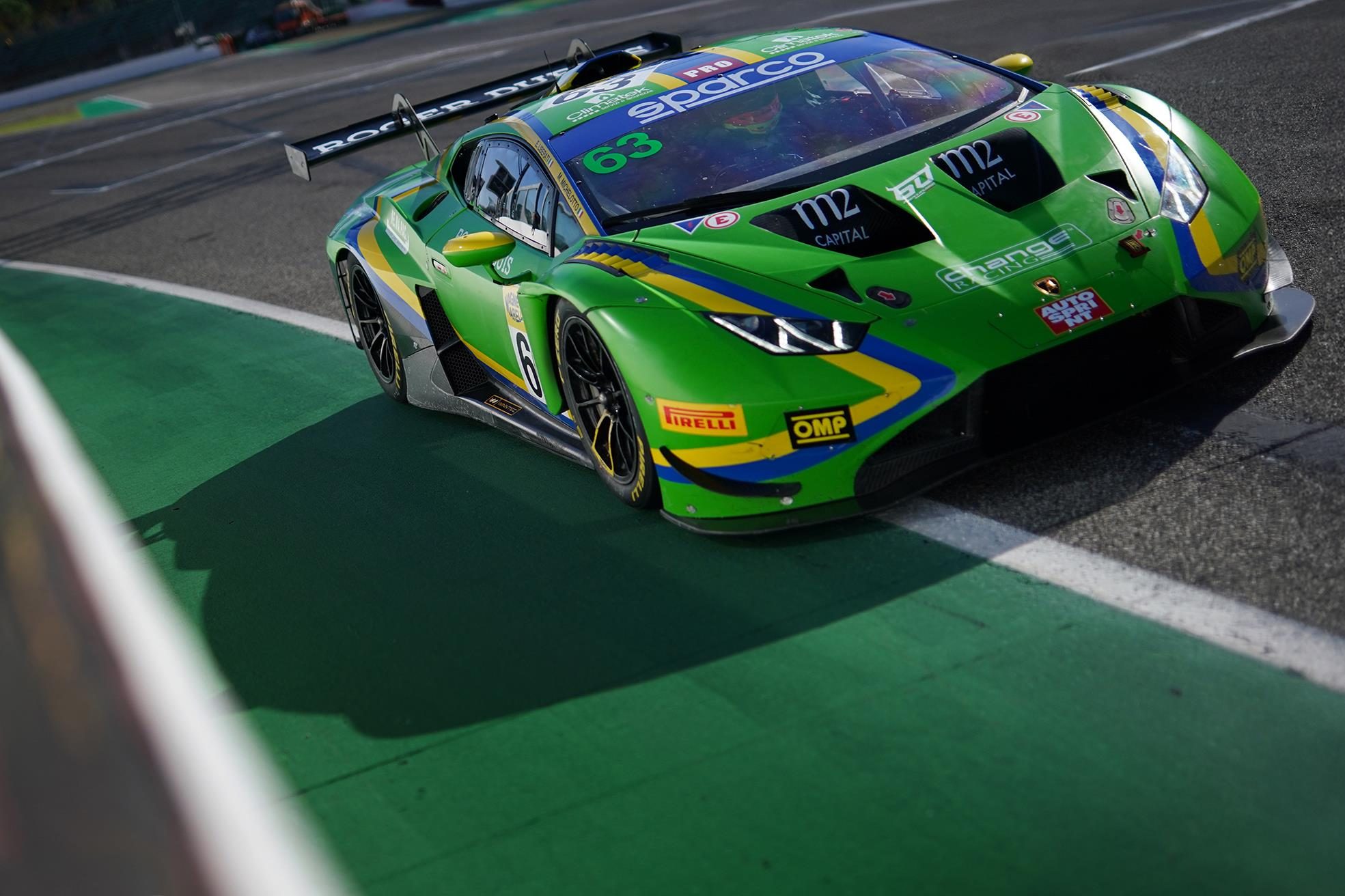 Lamborghini Swept Every Race At Imola And Still Lost The Italian Gt Sprint Title On Countback 3 Overhead view of a green lamborghini huracán gt3 evo2 in racing livery navigating a corner at imola with a long shadow cast across the track