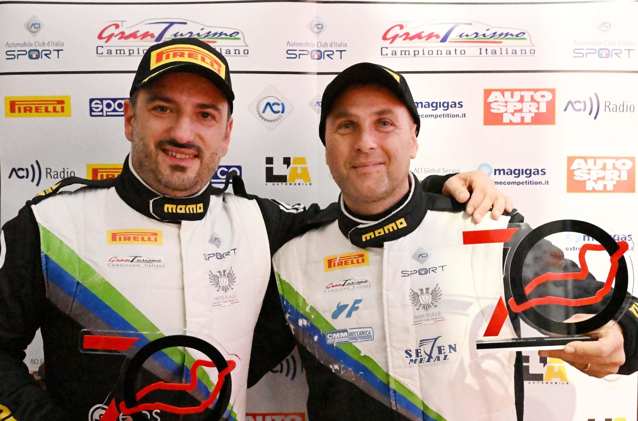 Lamborghini Swept Every Race At Imola And Still Lost The Italian Gt Sprint Title On Countback 5 Two lamborghini racing drivers holding trophies and smiling against a backdrop of sponsor logos after winning their class title at imola