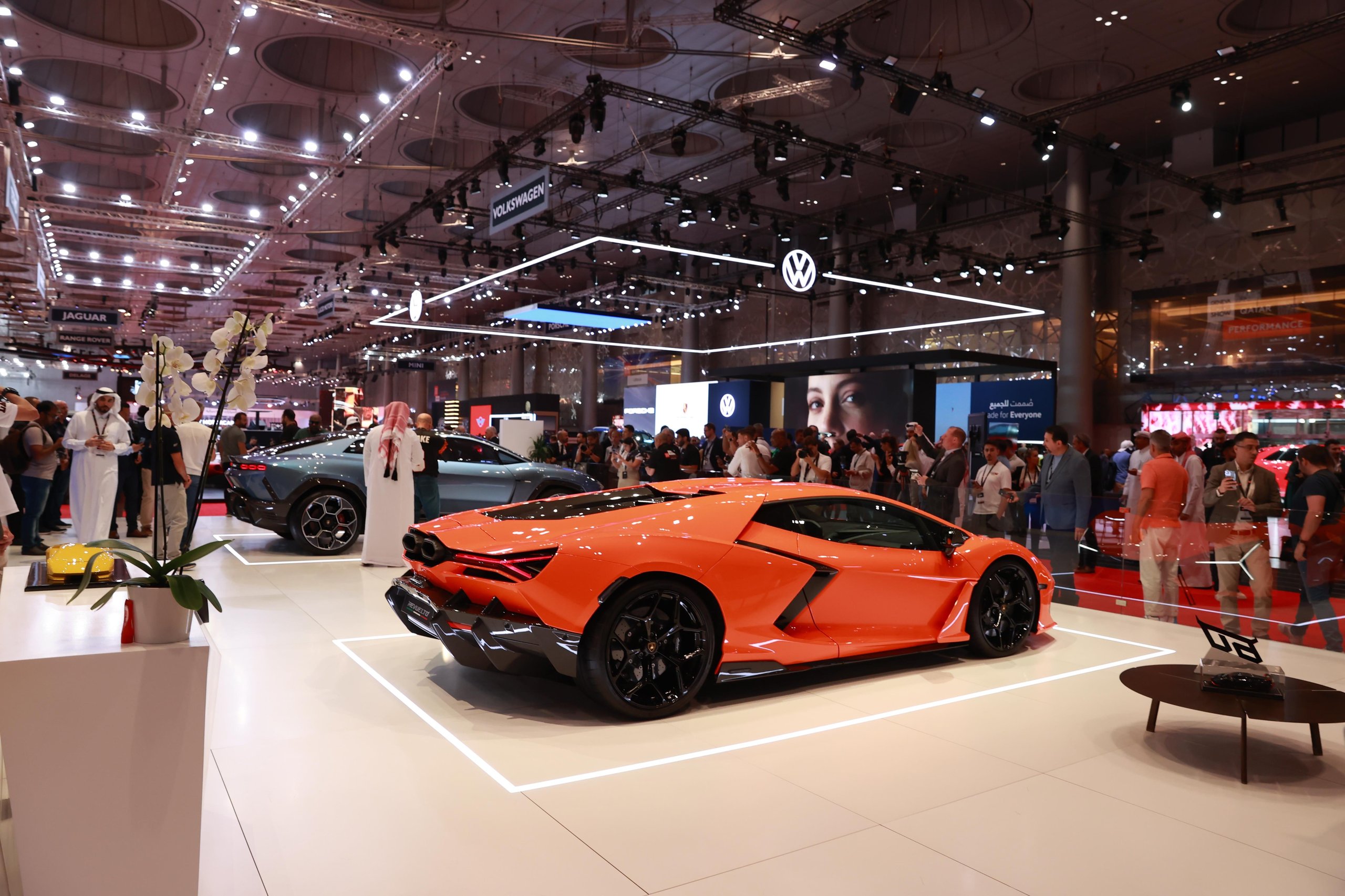 Lamborghini'S Lanzador Was The Star Of Gims Qatar. Then The Company Killed It. 3 Orange lamborghini revuelto displayed at gims qatar with attendees surrounding the car