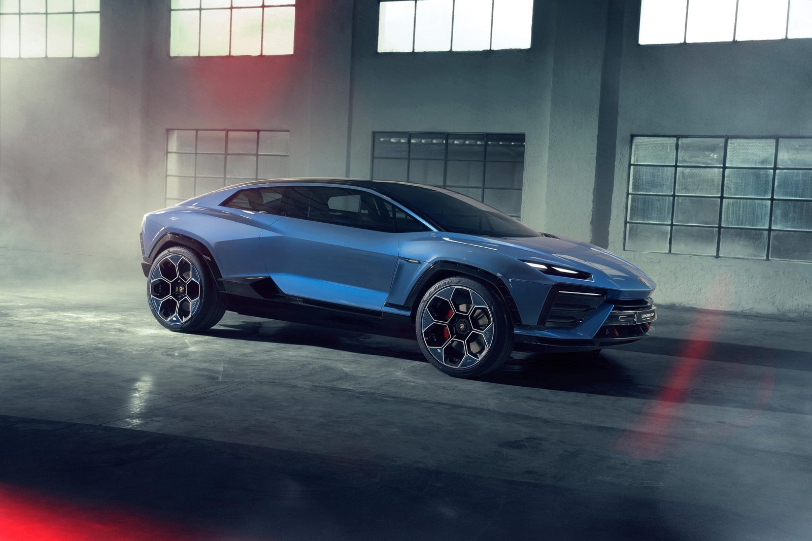 Blue Lamborghini Lanzador Concept in an industrial garage showing its elevated stance, sharp lines, and coupe-like roofline