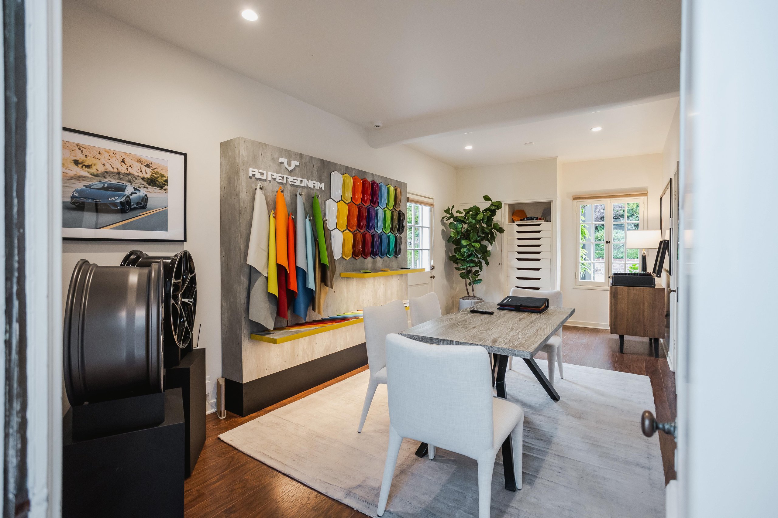 Interior of lamborghini ad personam customization studio at lounge monterey with color swatches, material samples, and configuration table