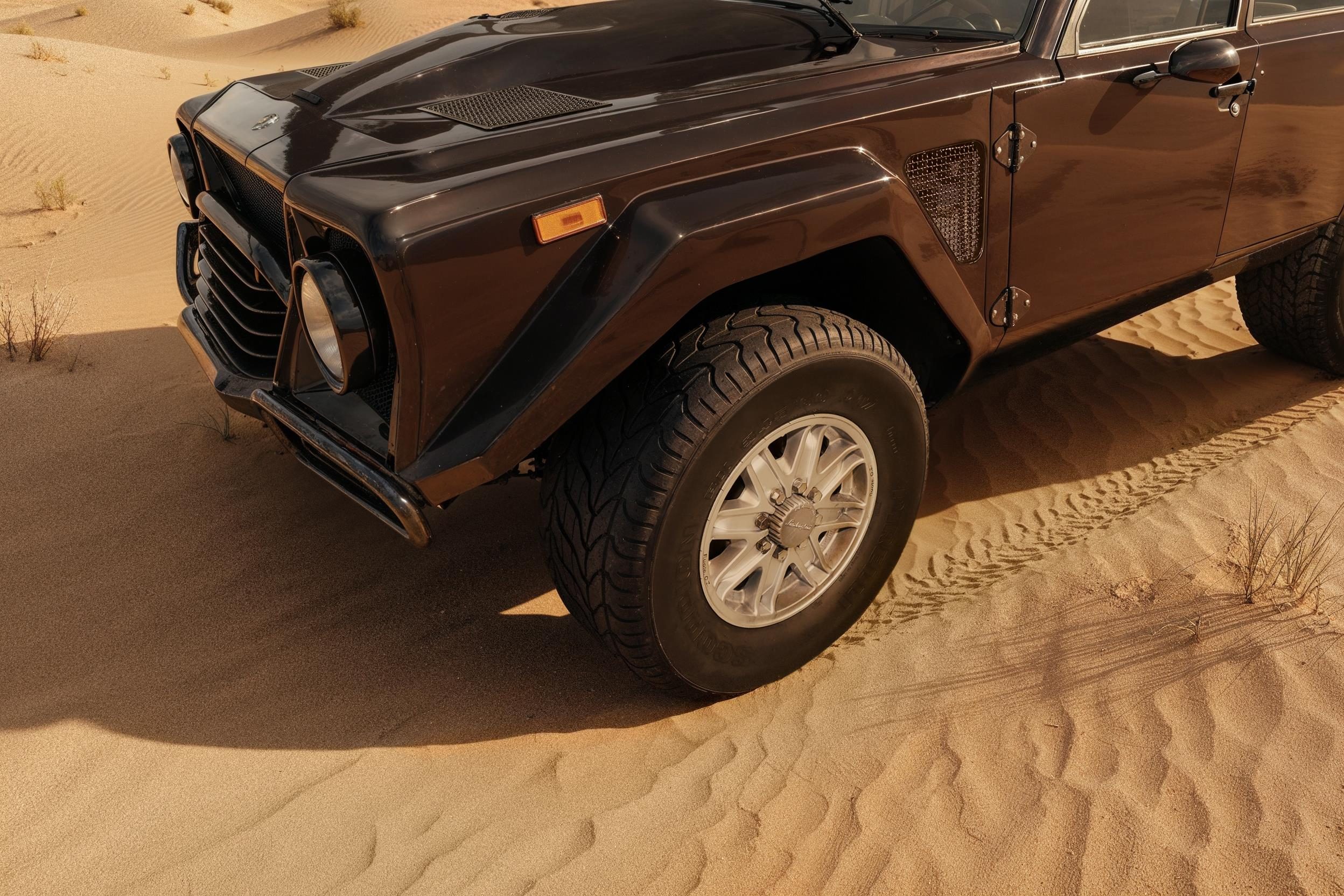 The 'Rambo Lambo' At 40: How Lamborghini'S V12 Off-Roader Invented The Super Suv And Paved The Road To The Urus 11 Close-up of front wheel and pirelli scorpion tire on brown lm002 in desert sand