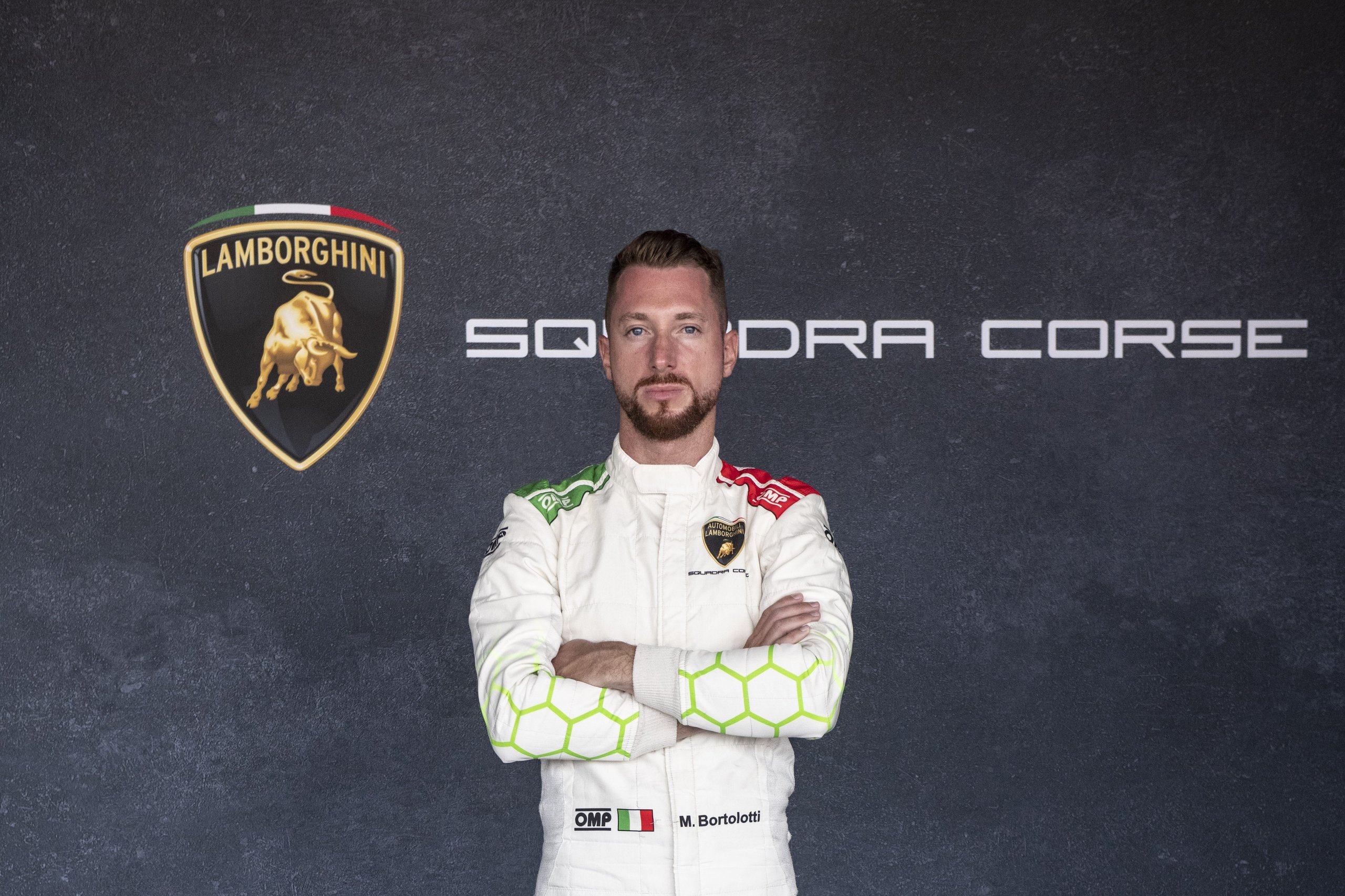 Caldarelli And Bortolotti: Why Lamborghini Built Its Lmdh Program On Gt Loyalty 3 Mirko bortolotti in lamborghini squadra corse white racing suit with green and red accents, arms crossed, against a dark background with squadra corse branding