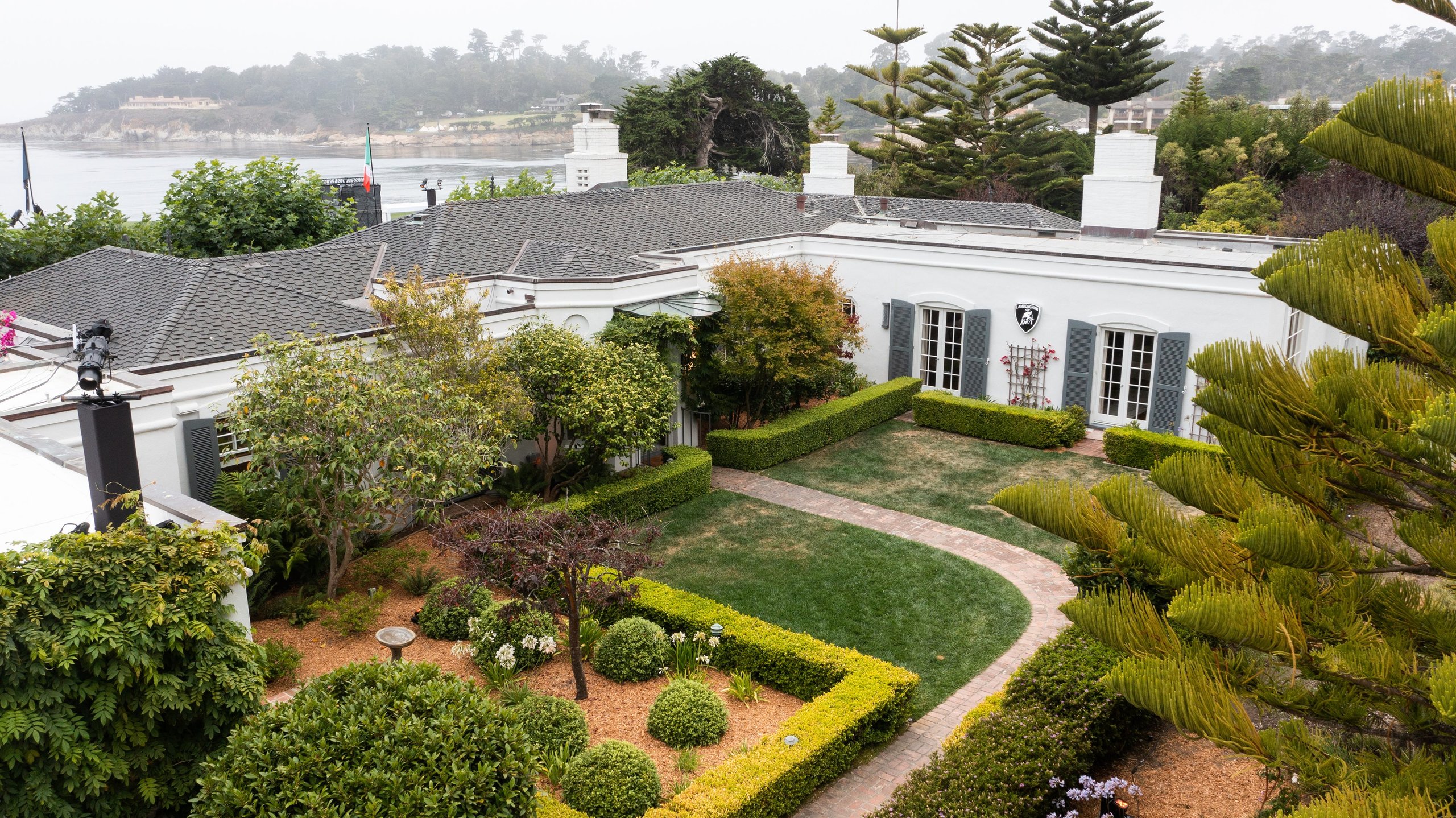 Inside Lamborghini'S Lounge Monterey: Where The Urus Performante Debut Became A Masterclass In Selling A Lifestyle 3 Aerial view of the white lamborghini lounge monterey villa with manicured gardens overlooking the water and distant hills