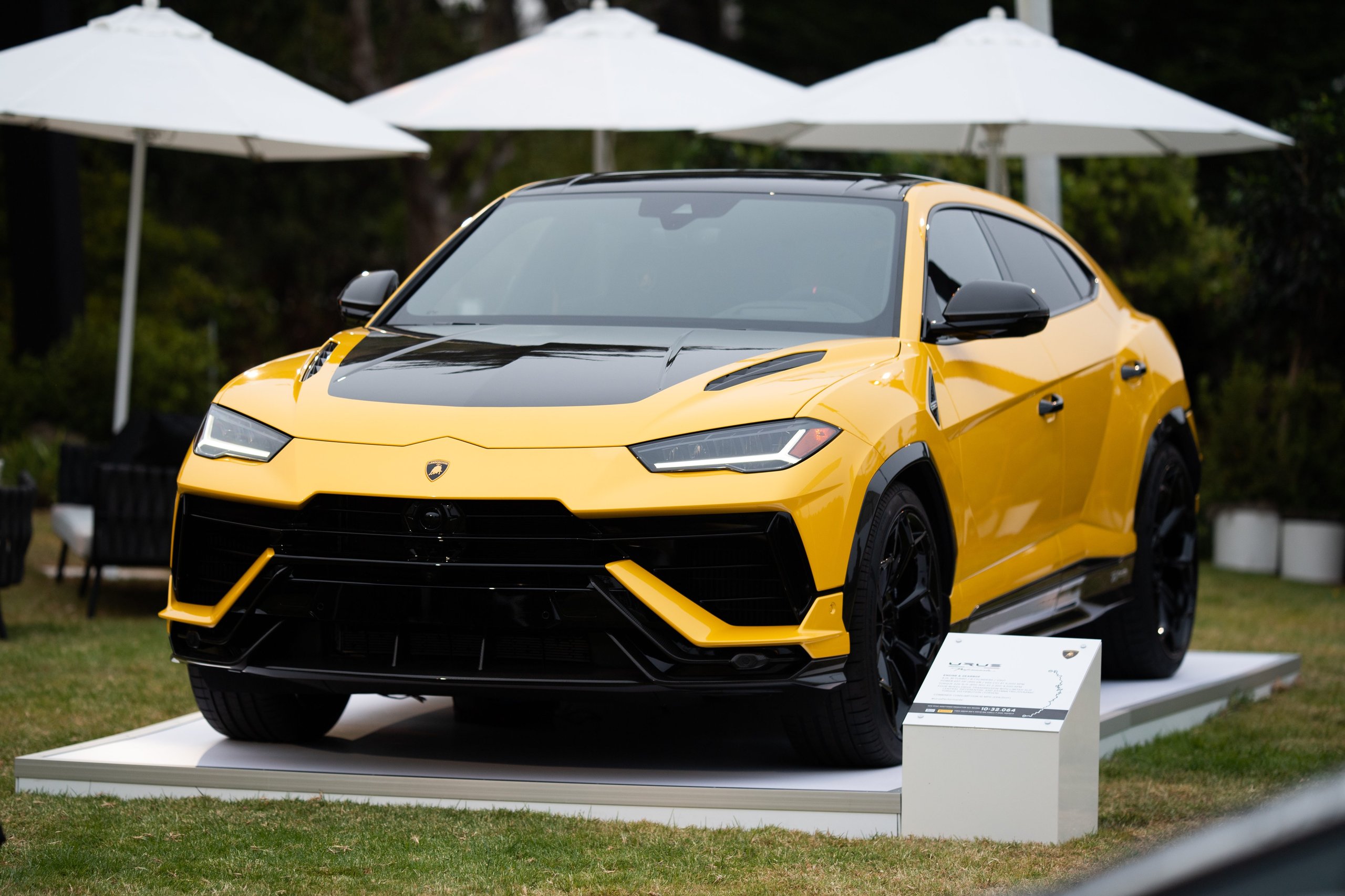 Inside Lamborghini'S Lounge Monterey: Where The Urus Performante Debut Became A Masterclass In Selling A Lifestyle 7 Bright yellow lamborghini urus performante with black accents displayed on a white platform on a grassy lawn at the lounge monterey