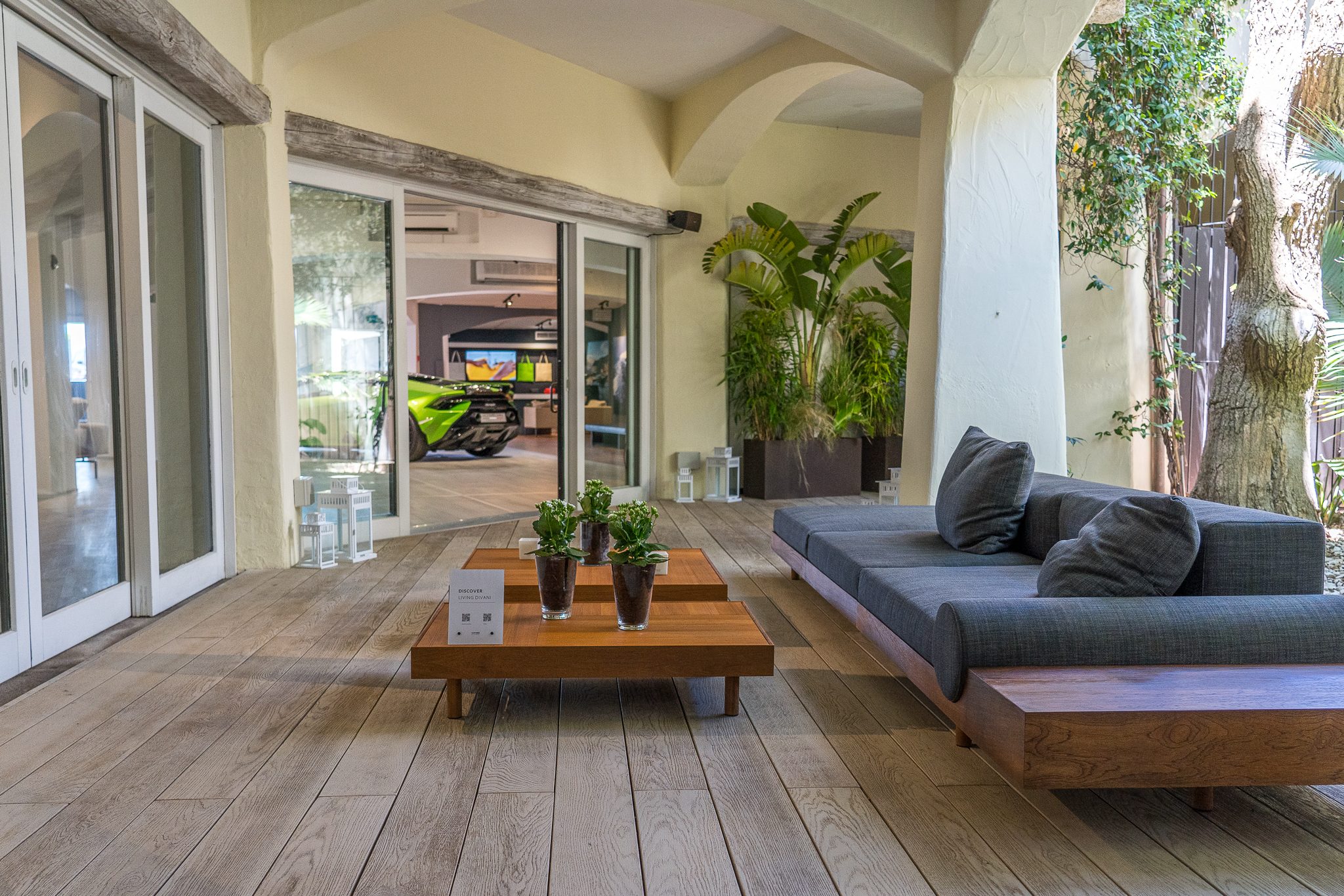 Lamborghini'S Porto Cervo Pop-Up Is A Masterclass In Selling The Supercar Life, Not Just Supercars 13 Green lamborghini huracán visible through glass doors of the porto cervo lounge with outdoor patio seating