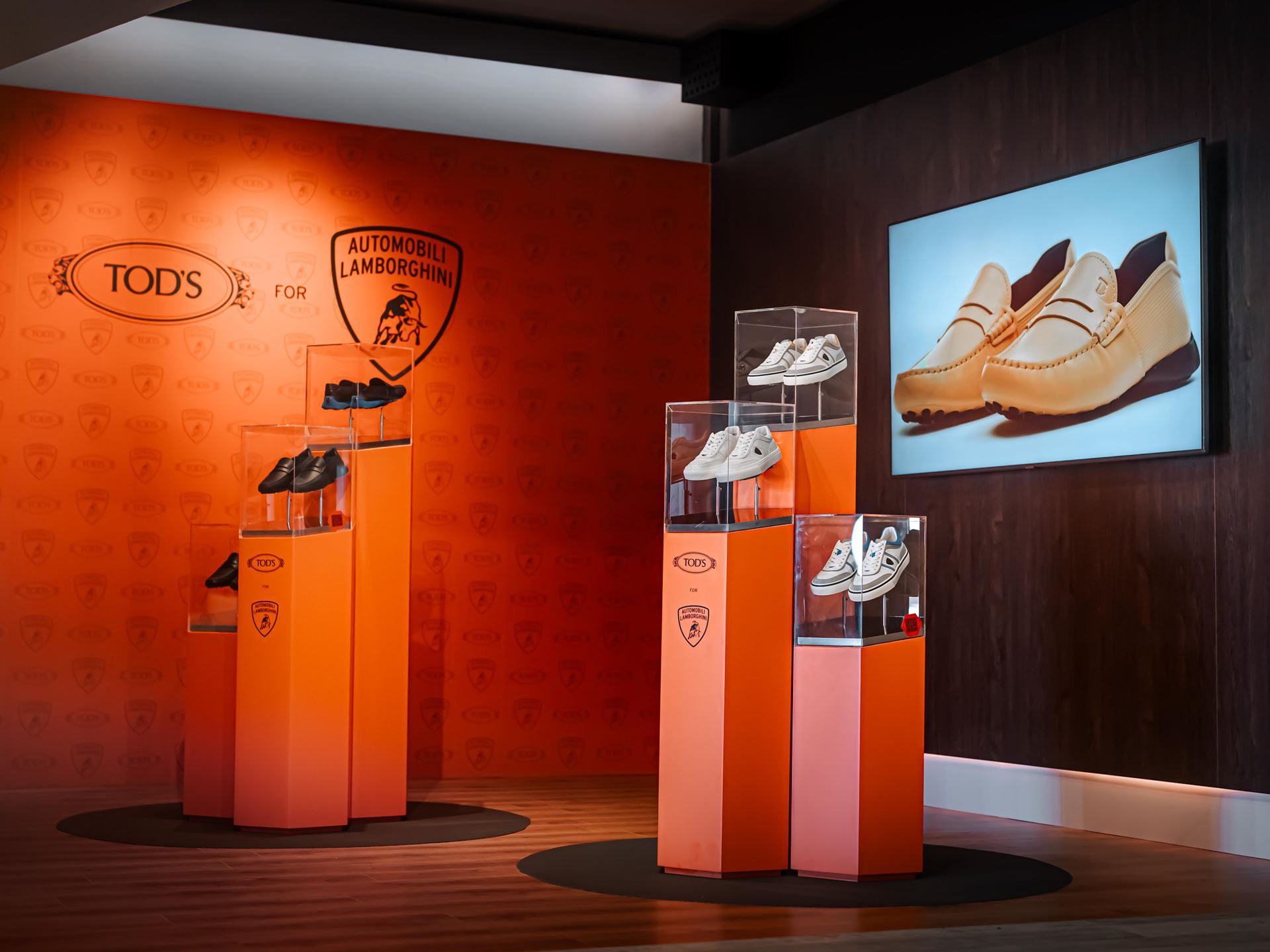 Lamborghini'S Porto Cervo Lounge Returns For A Sixth Summer As A Seaside Brand Hub 9 Display of tod's for automobili lamborghini footwear collection featuring various styles on orange pedestals