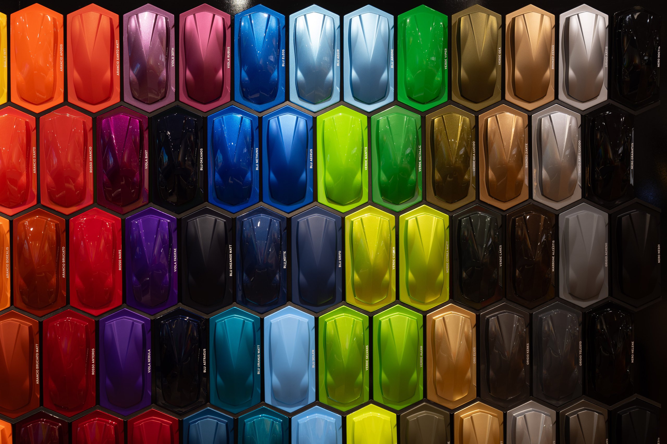 Inside Lamborghini'S Porto Cervo Lounge, Where The Revuelto Meets Its Future Owners 9 Full wall display of lamborghini exterior paint samples in hexagonal pattern showing a vast spectrum of colors and finishes
