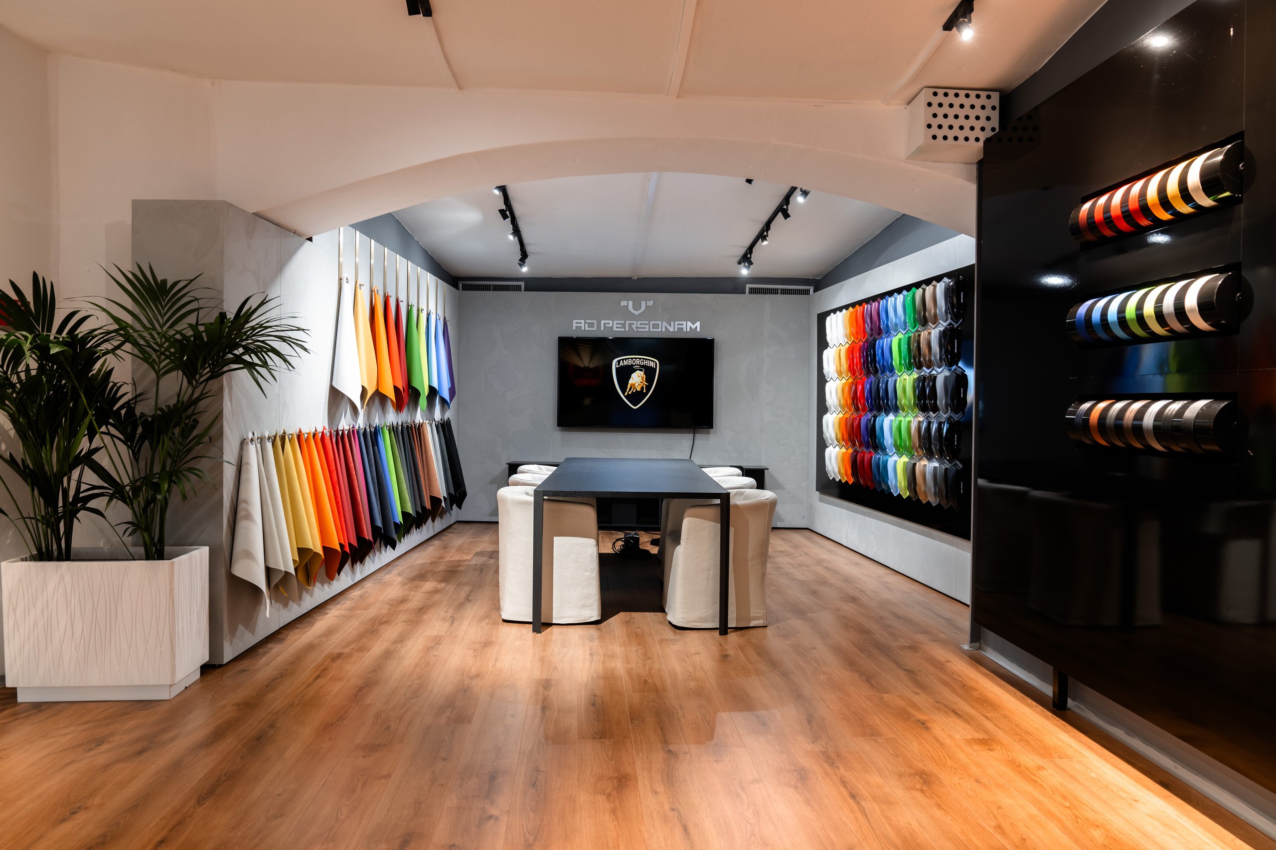 Inside Lamborghini'S Porto Cervo Lounge, Where The Revuelto Meets Its Future Owners 5 Lamborghini ad personam studio with central table, lamborghini logo screen, and walls of material and color samples
