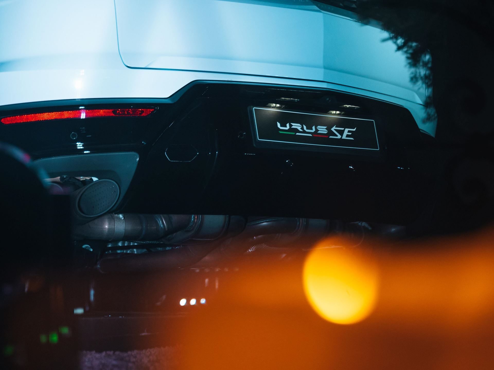 Lamborghini Lugano Turned Its First Birthday Into A Lakeside Stage For The Urus Se'S Swiss Debut 7 Close-up low-angle shot of the rear bumper and exhaust of a white lamborghini urus se showing the urus se badge