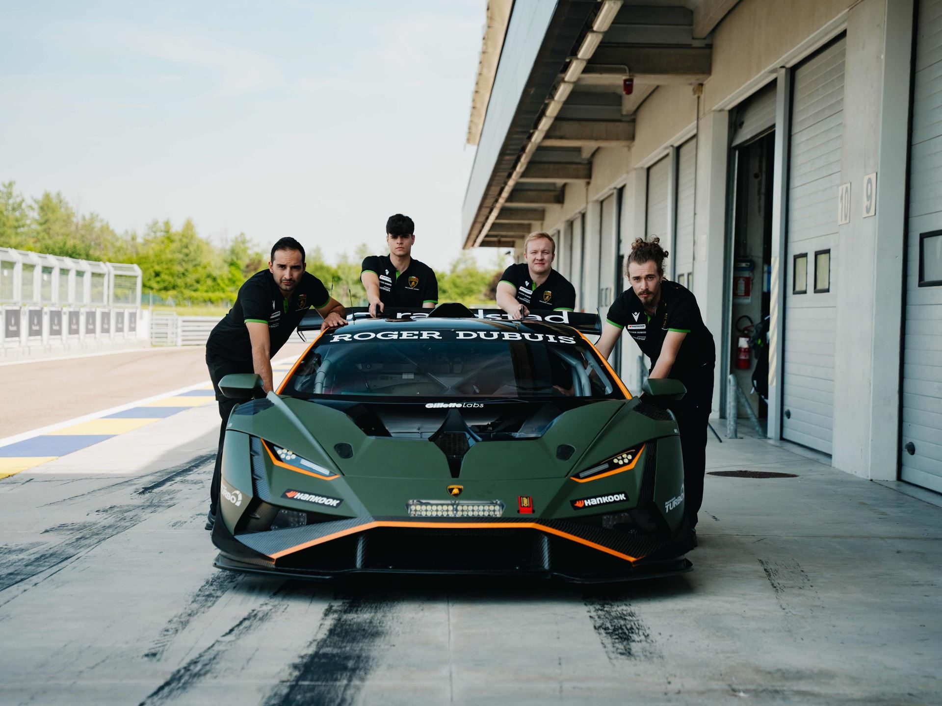 Lamborghini Taps Macron To Outfit Squadra Corse For Three Seasons, Replica Collection Included 13 Four mechanics in lamborghini squadra corse shirts push a green and orange huracán gt3 evo2 out of a pit garage onto a racetrack