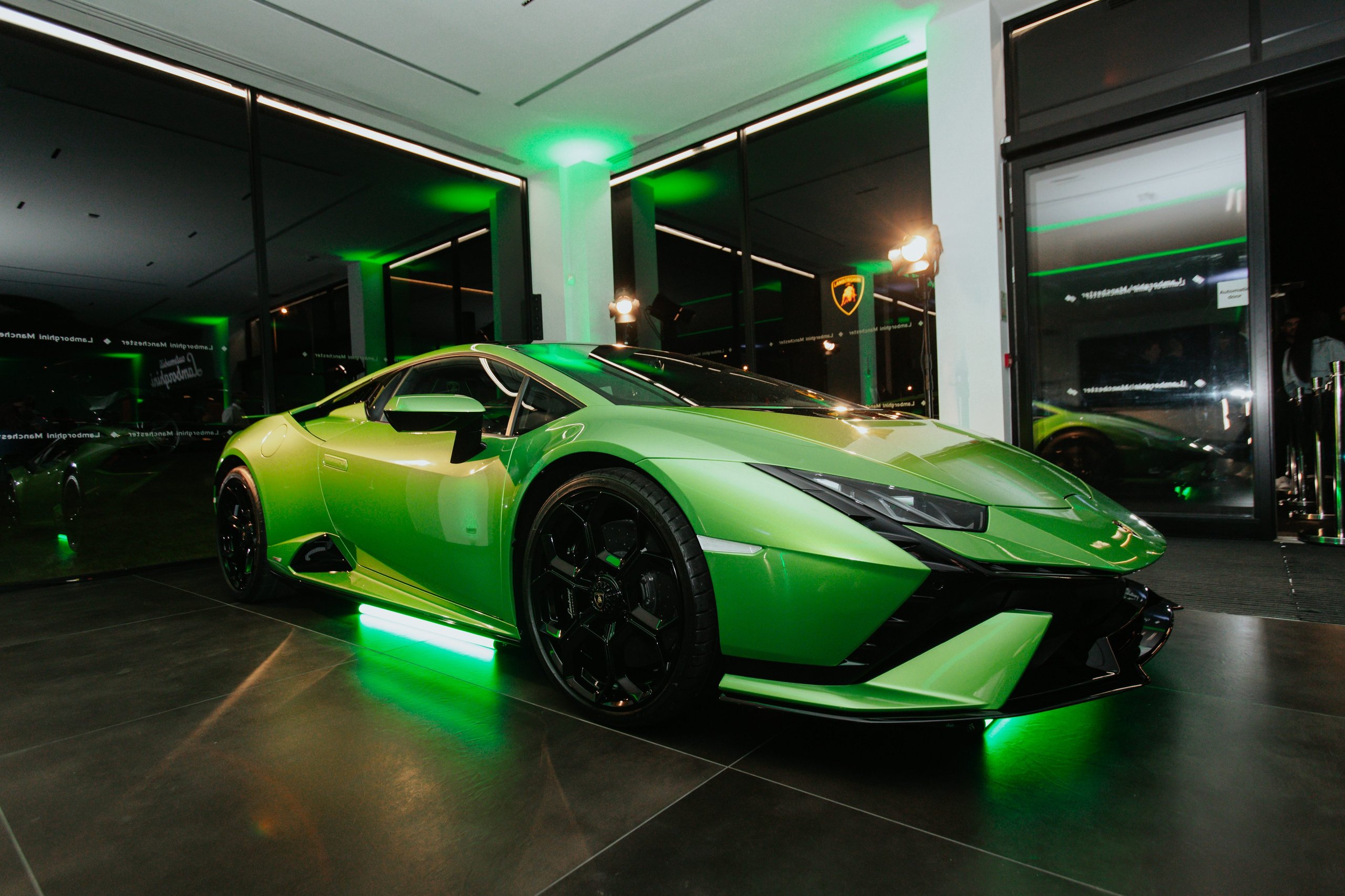 Lamborghini Manchester'S New Stockport Showroom Signals Where The Brand Is Placing Its Uk Bets 9 Green lamborghini huracán displayed under dramatic green lighting inside the lamborghini manchester showroom